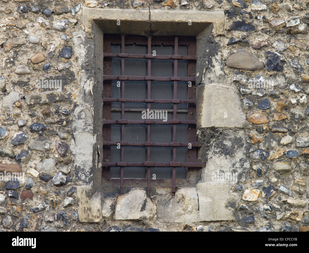 Une vieille fenêtre barrée dans un mur de pierre brute. Banque D'Images