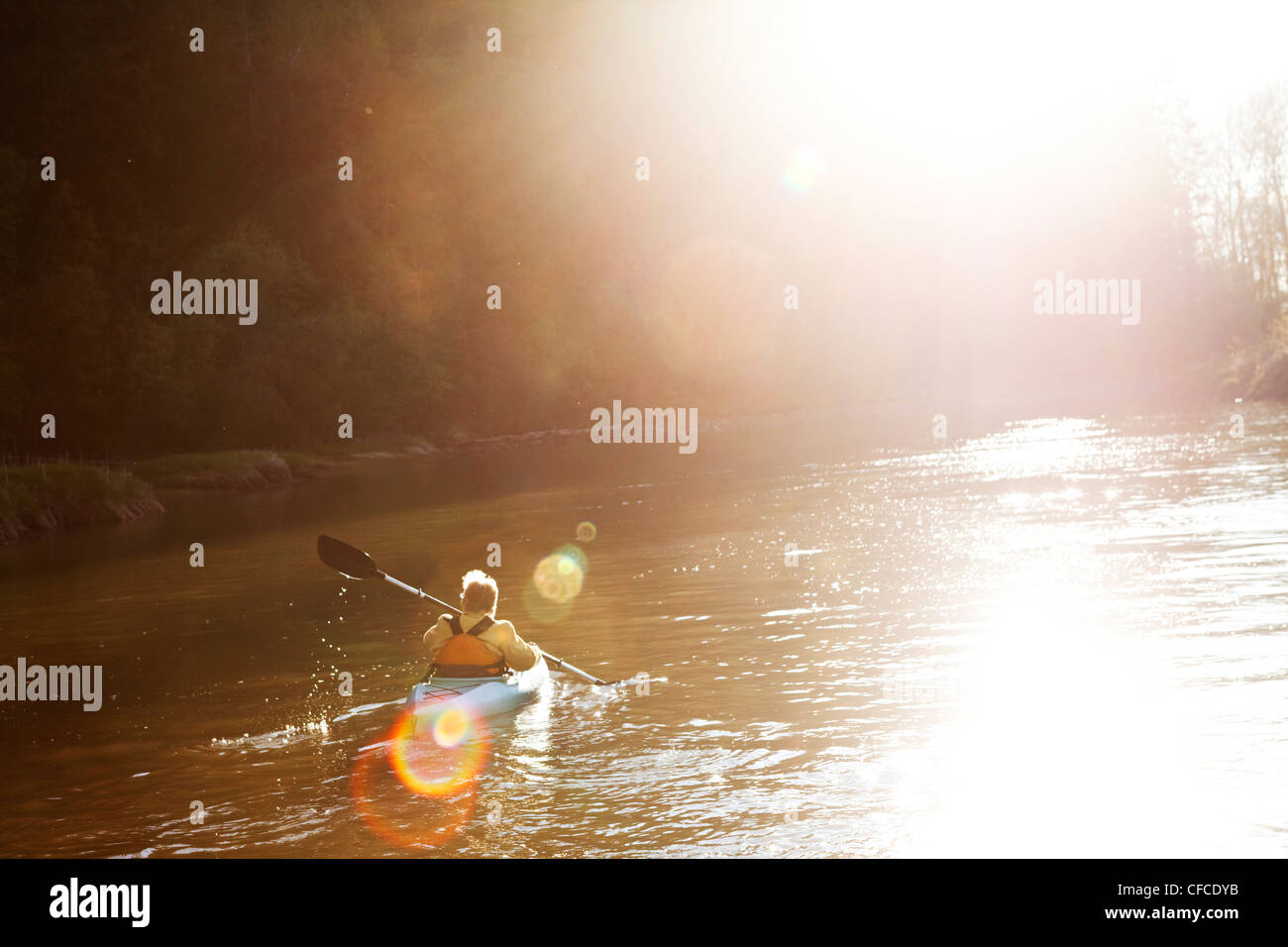 Les femmes à la retraite l'aventure Kayak vers le bas une grande rivière au coucher du soleil dans l'Idaho. Banque D'Images
