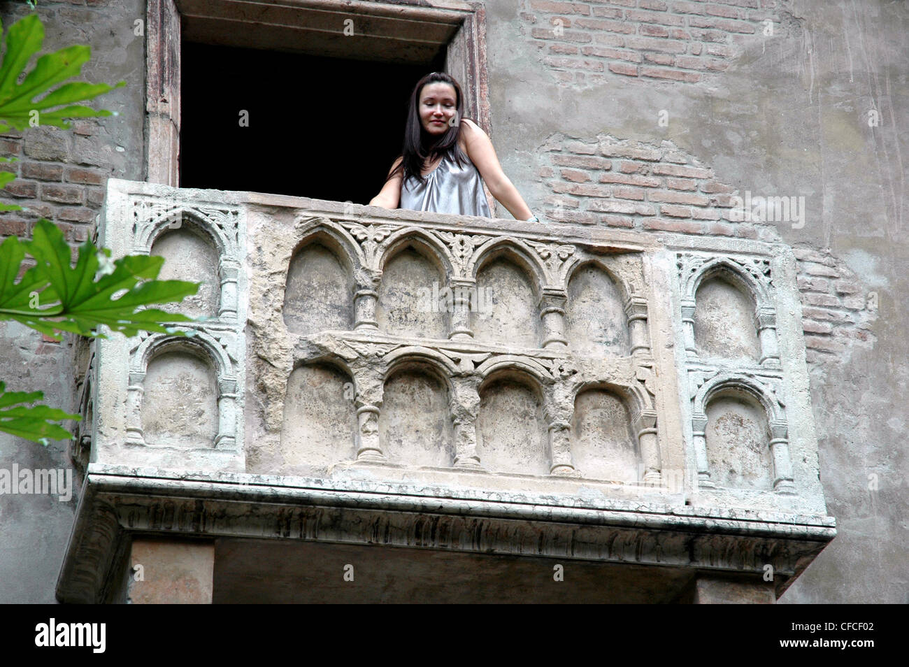 Une jeune femme pose, comme Juliette, sur le célèbre balcon à Vérone Italie Banque D'Images