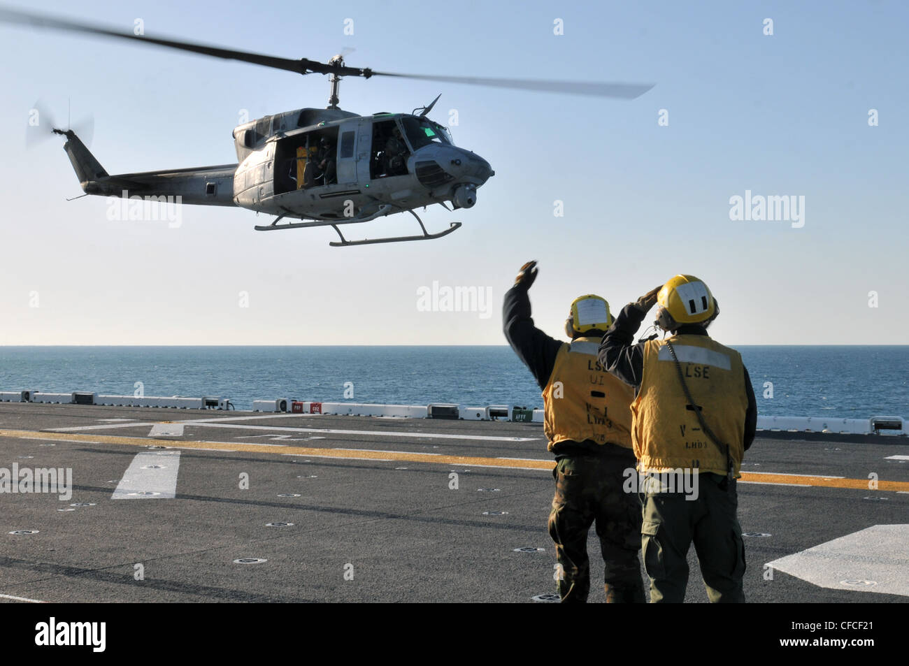Les copains de l'aviation de Boatswain dirigent le décollage d'un HUEY UH-1N sur le pont de vol du navire d'assaut amphibie USS Kearsarge. Kearsarge est en cours, en train de terminer la formation de base du groupe de formation 1.3. Banque D'Images