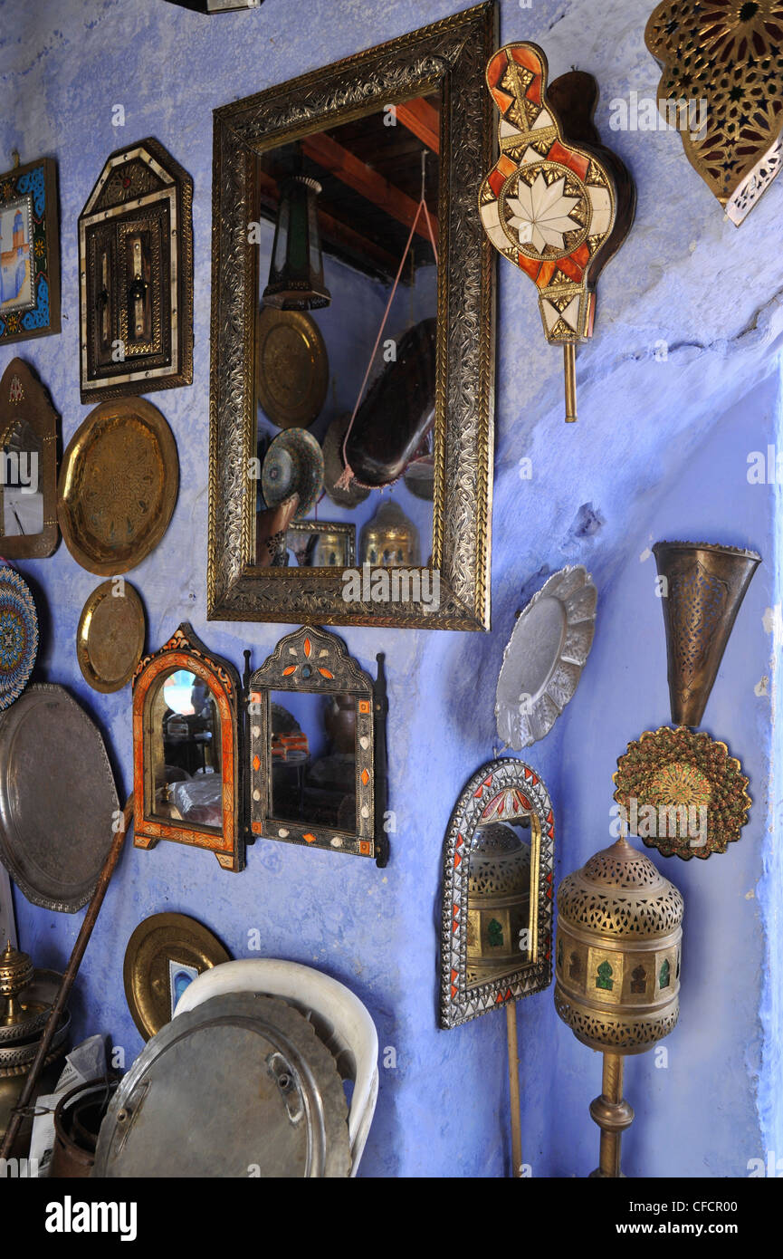 Miroir et plaques d'argent sur un mur bleu et porte d'un magasin dans une ruelle étroite à Chefchaouen, Maroc, montagnes Riff, Afrique Banque D'Images