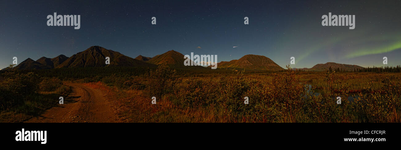 Vue panoramique des montagnes de lune, près de Whitehorse avec aurora et l'étoile filante dans le ciel de nuit. Banque D'Images