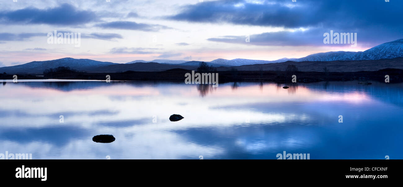 Voir l'aube du Loch Ba qui reflètent le ciel et les montagnes enneigées, Rannoch Moor, Highland, Ecosse, Royaume-Uni Banque D'Images