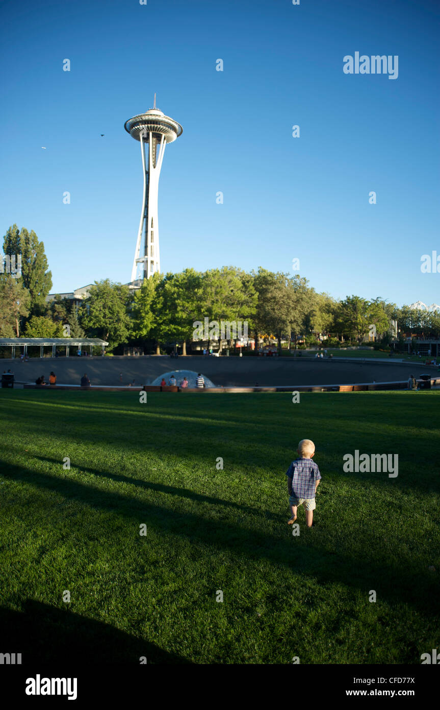 Tout-petit marche sur pelouse vers Space Needle de Seattle Center, Seattle, État de Washington, États-Unis d'Amérique, Banque D'Images