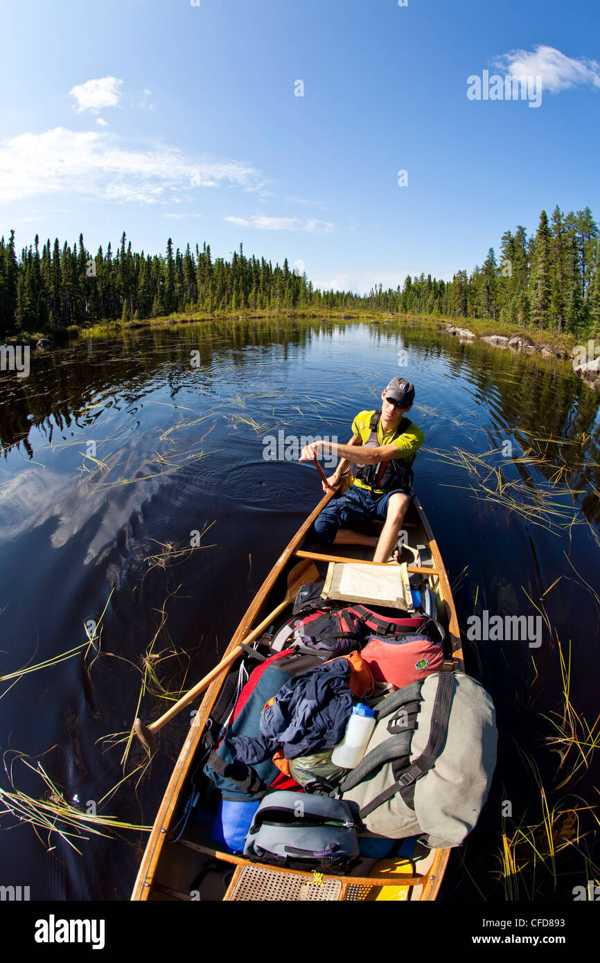 Un jeune homme canoë et camping pour 2 semaines dans le parc provincial Wabakimi, Nord de l'Ontario, Canada Banque D'Images