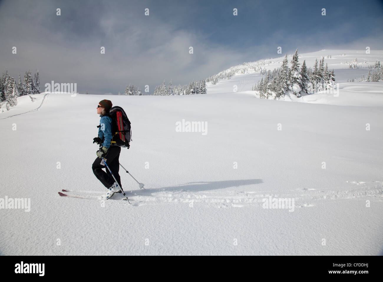 Une femelle skieur d'arrière-pays se brise chemin dans la neige. Banque D'Images