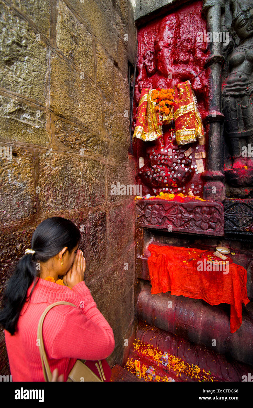 Pèlerin en face d'une statue en pierre de couleur rouge dans le temple hindou Kamakhya, Guwahati, Assam, Inde, Asie Banque D'Images