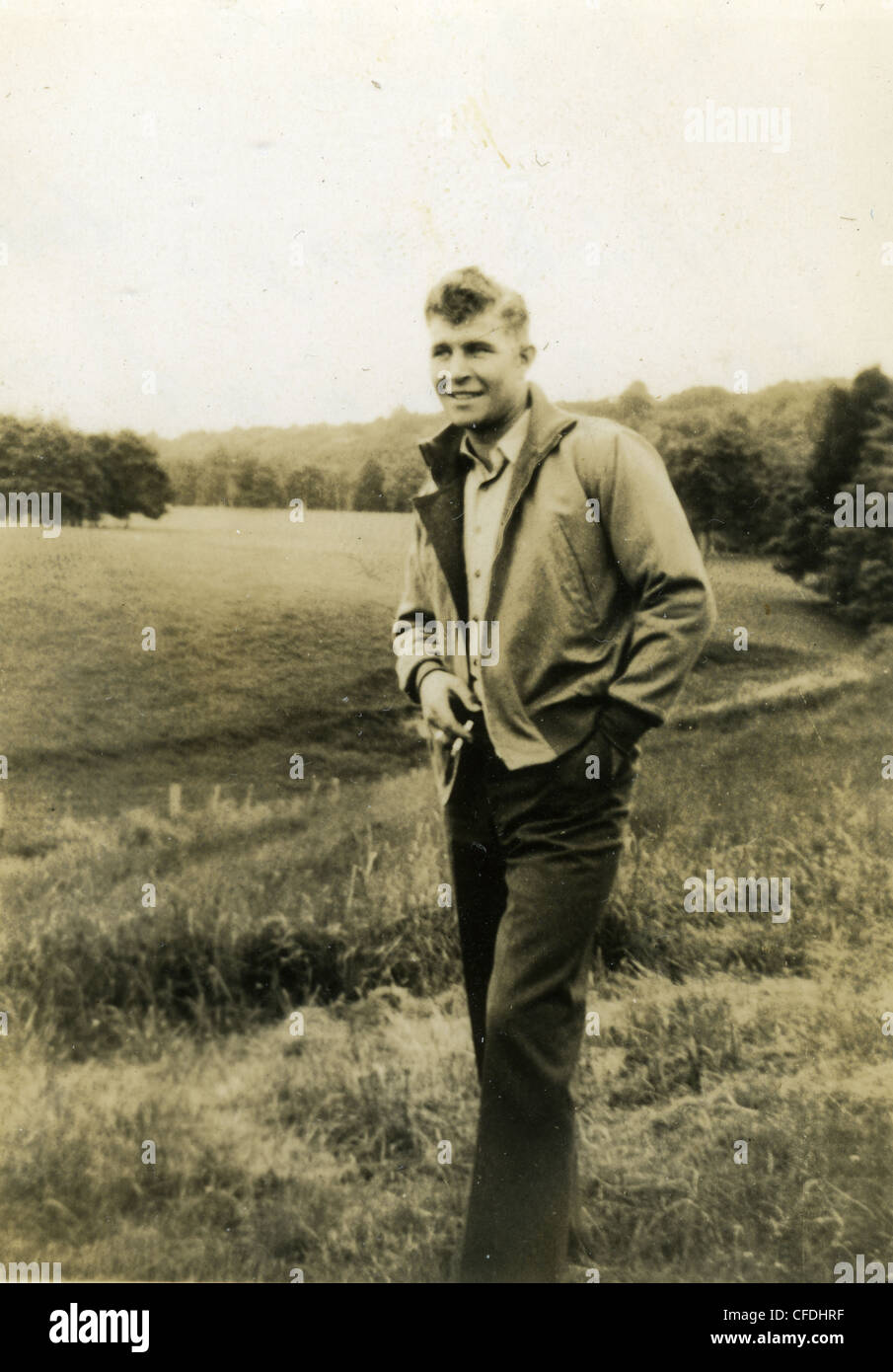 Jeune homme à la mode pendant la DEUXIÈME GUERRE MONDIALE 1940 plus grande génération fumeur fumeur scène rural farm Banque D'Images