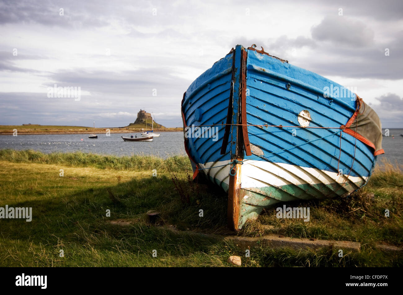 Bleu bateau sec pour l'hiver, avec Château de Lindisfarne en arrière-plan Banque D'Images