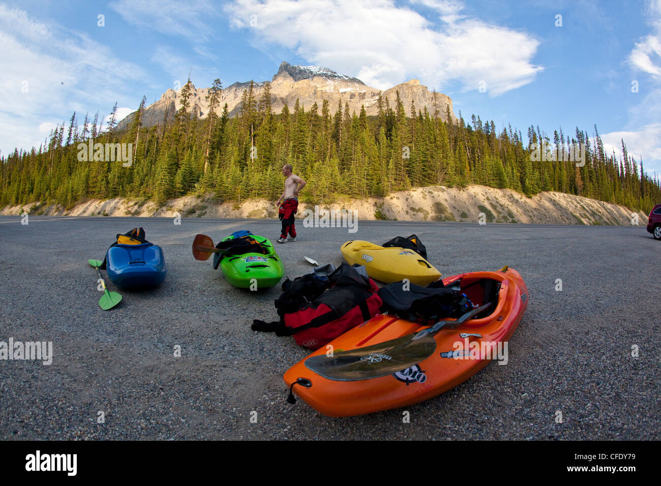 Un homme attend une navette après le kayak de rivière Mystia, Banff National Park, Alberta, Canada Banque D'Images