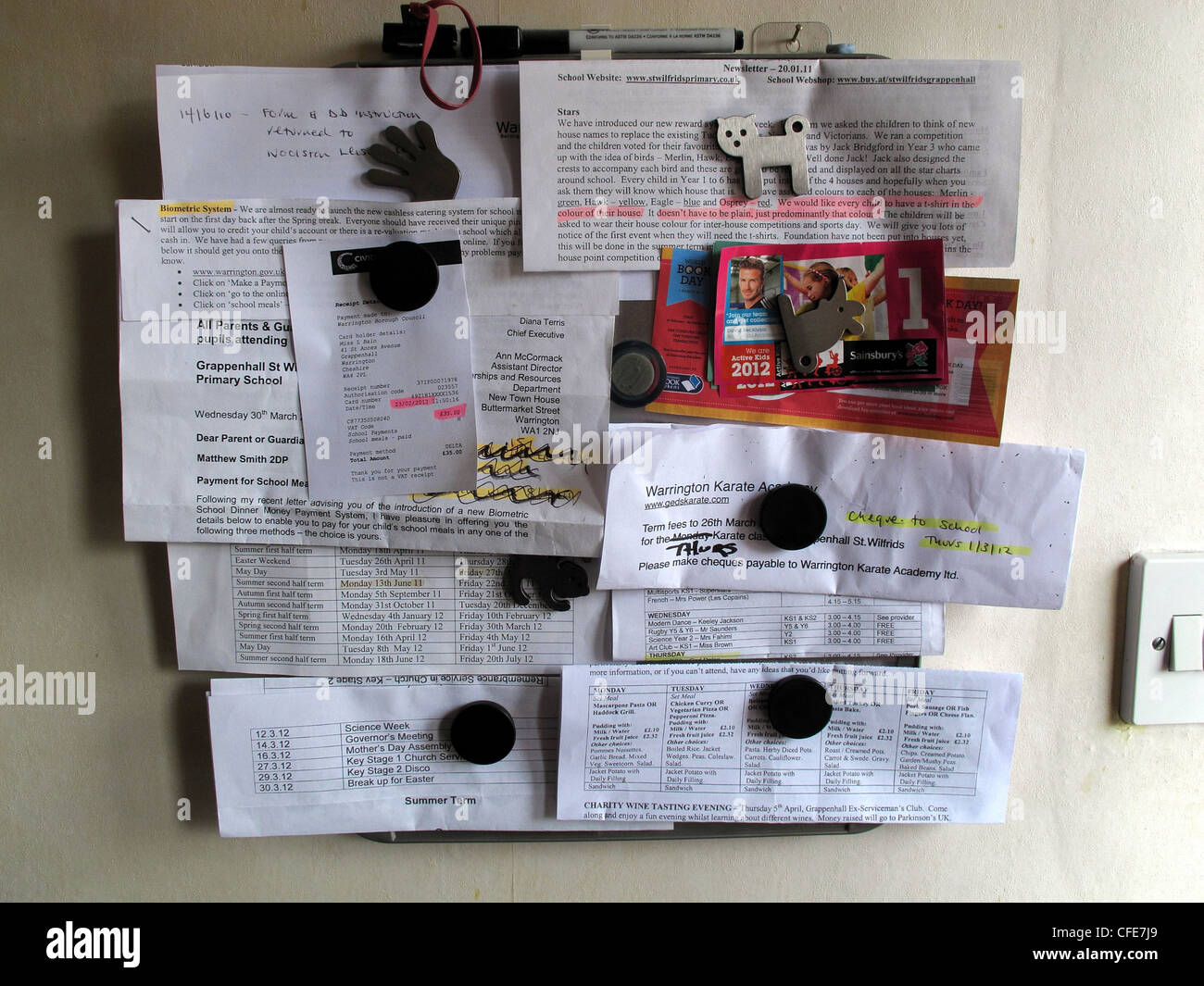 Tableau d'affichage magnétique des ménages avec des notes au sujet de l'école et d'autres activités en anglais Banque D'Images