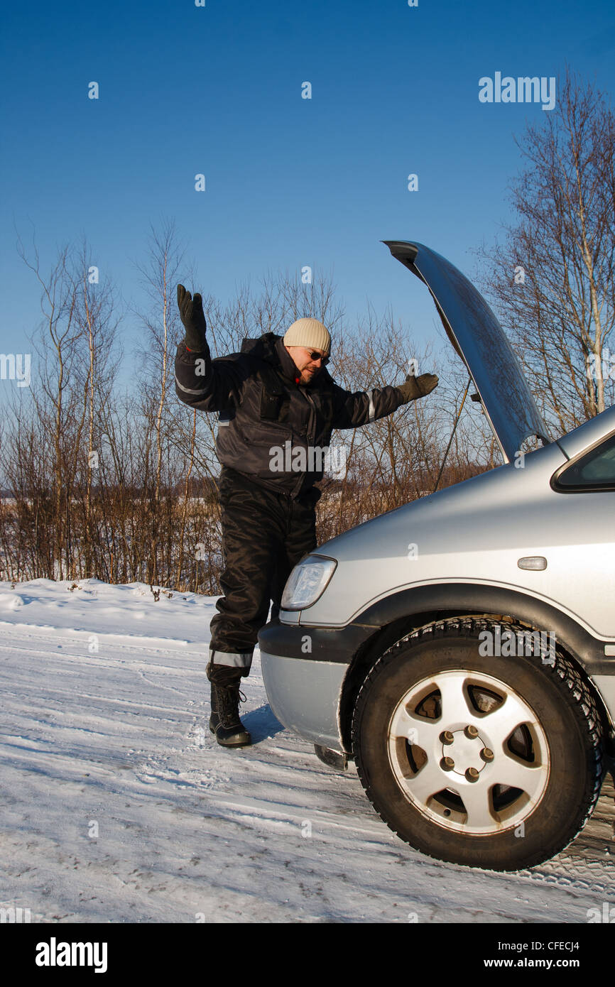 Dans froide journée d'hiver homme triste en regardant sa voiture cassée Banque D'Images