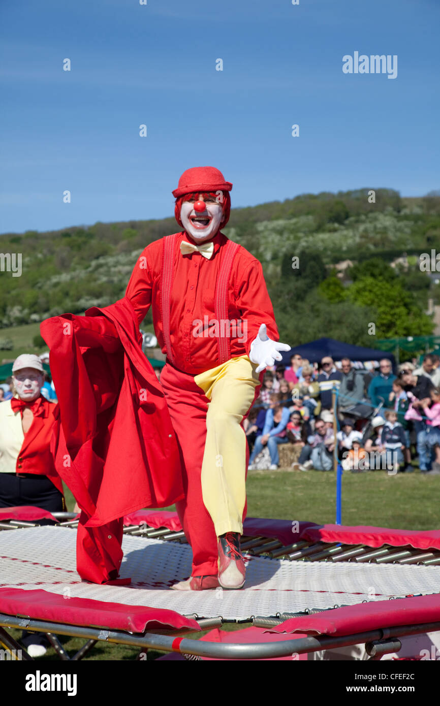 Clown au nez rouge veste rouge en jouant sur des célébrations 2011 Mayday  trampoline Woodmancote Cheltenham UK Photo Stock - Alamy