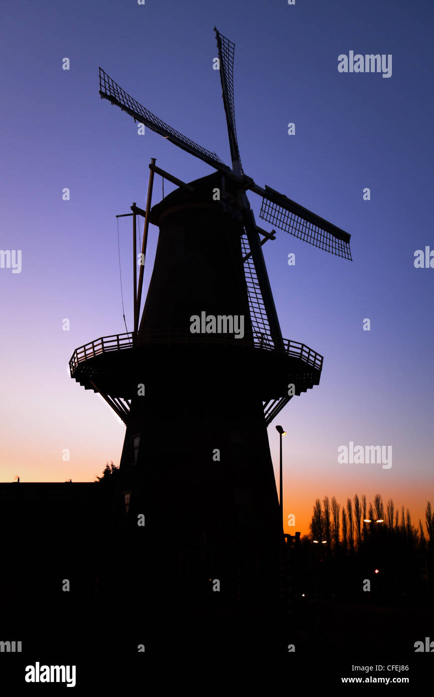 Silhouette de moulin à vent hollandais en ville avec les rues après le coucher du soleil Banque D'Images