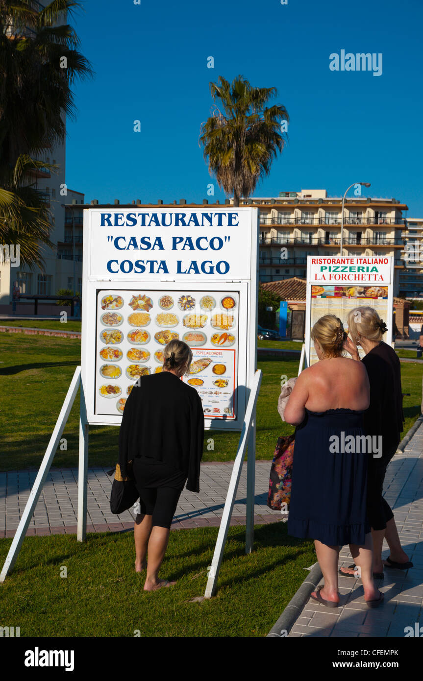 Les femmes à la recherche de menu au restaurant le long de la promenade Paseo Maritimo Torremolinos Costa del Sol Andalousie Espagne Banque D'Images