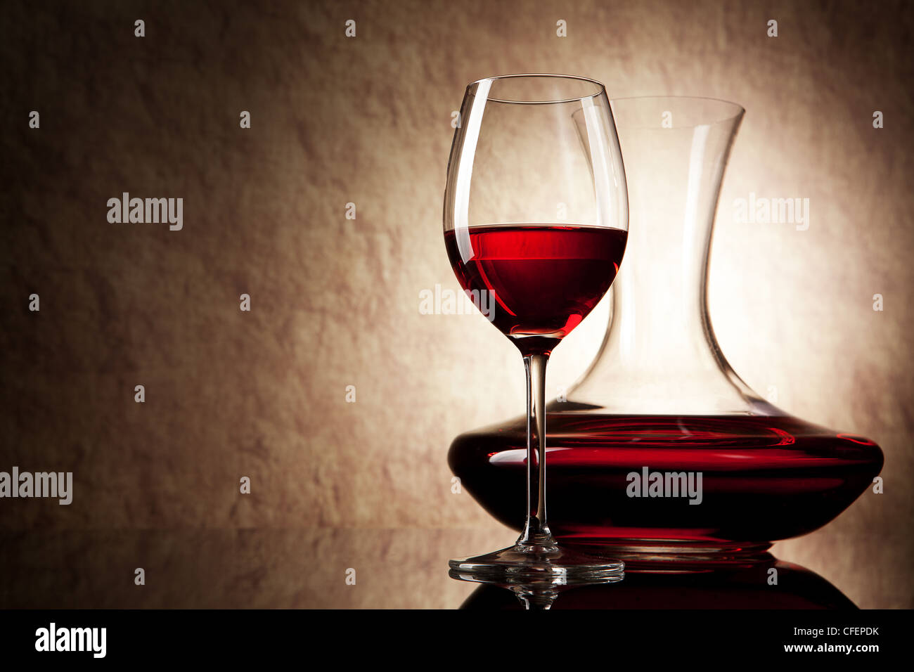 La carafe de vin rouge et le verre sur un fond de vieilles pierres Banque D'Images