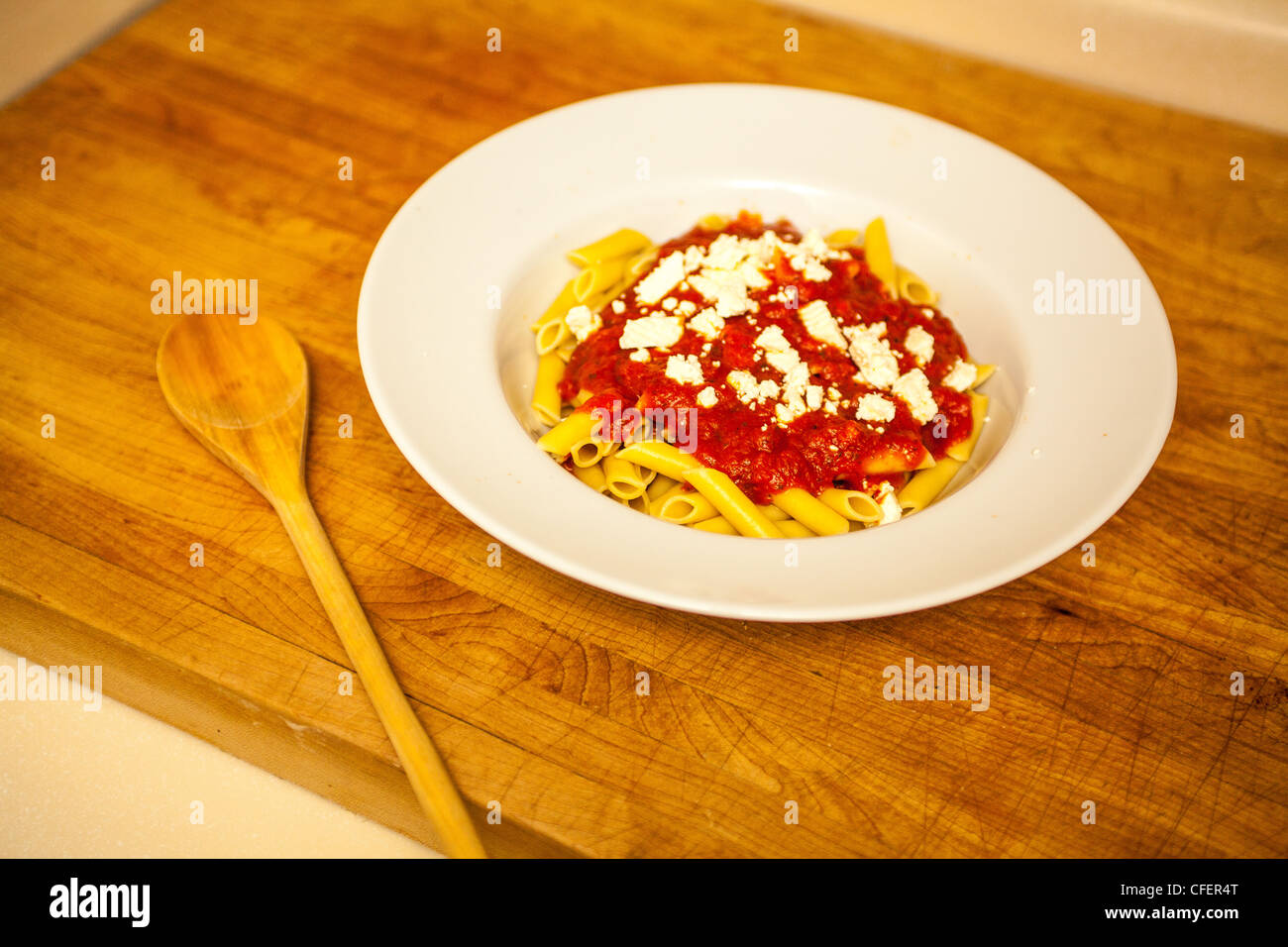 Un bol de pâtes avec sauce tomate mostaccioli garnie de fromage feta Banque D'Images