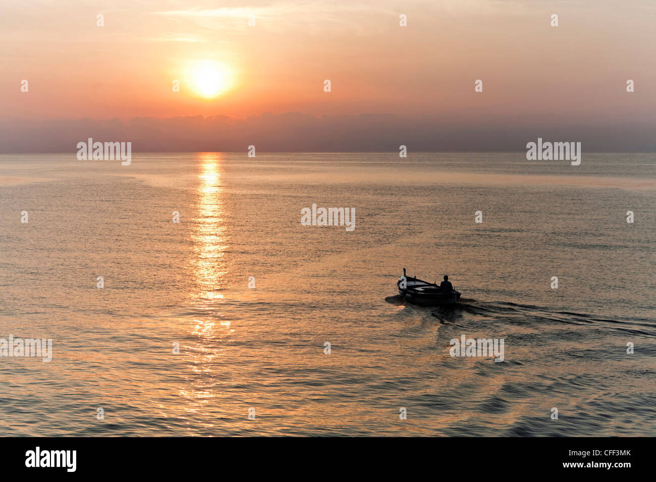 Bateau de pêcheur au lever du soleil à l'approche de la Mer Tyrrhénienne au large de Bastia, Corse, France Banque D'Images