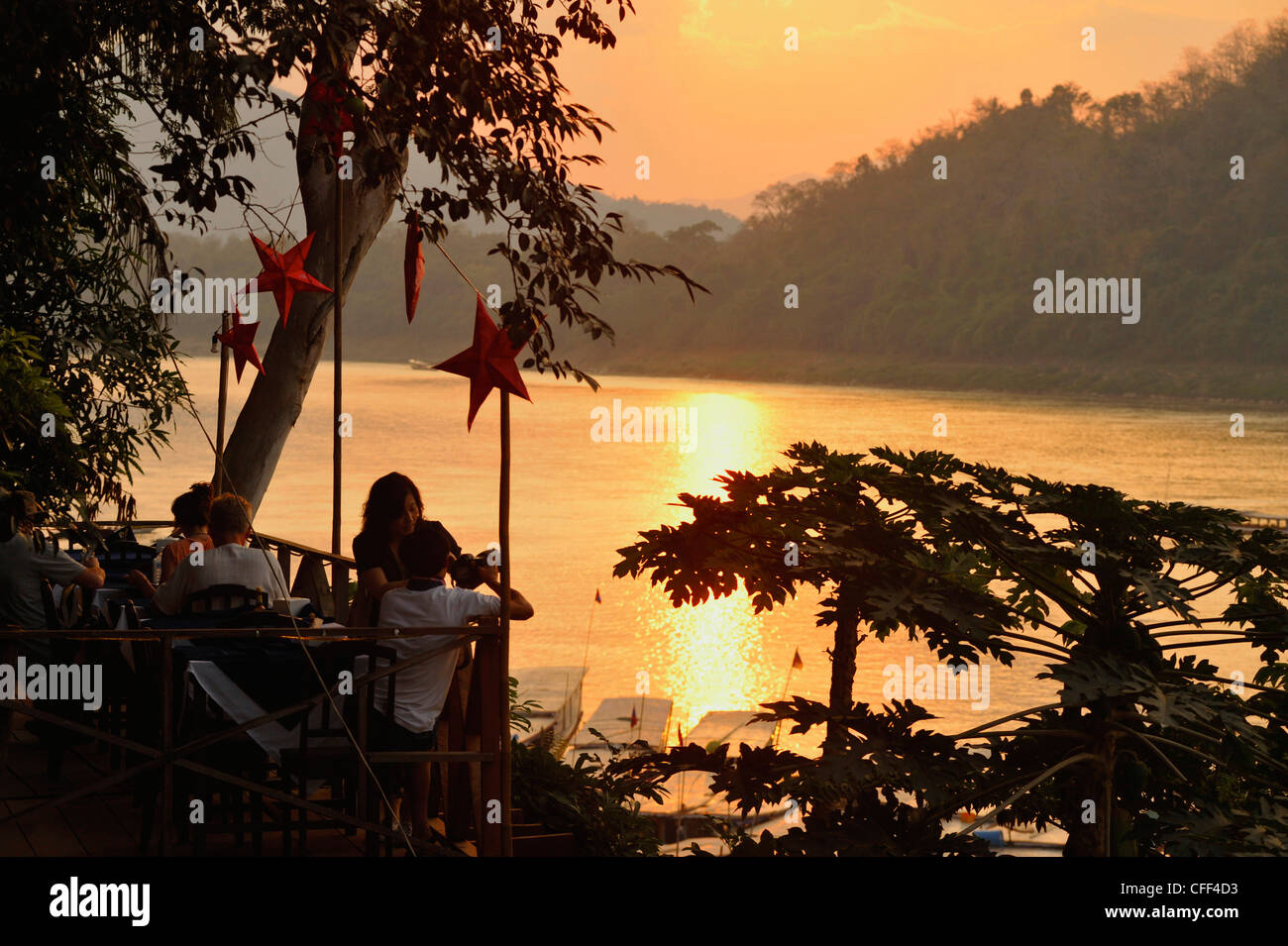 Restaurant donnant sur le fleuve du Mékong après le coucher du soleil, Luang Prabang, Laos Banque D'Images