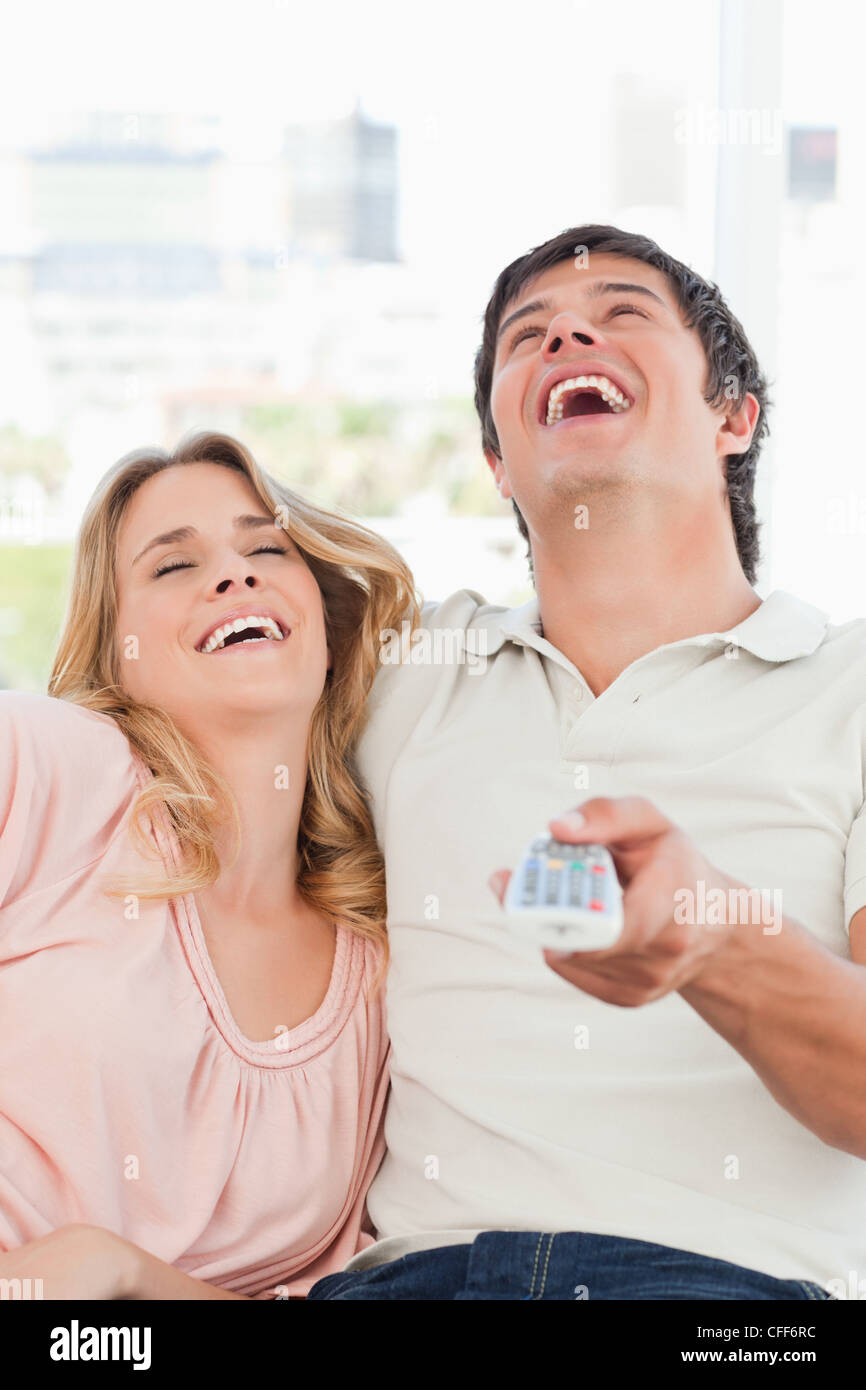 Close up, homme et femme en riant à un programme tv Banque D'Images