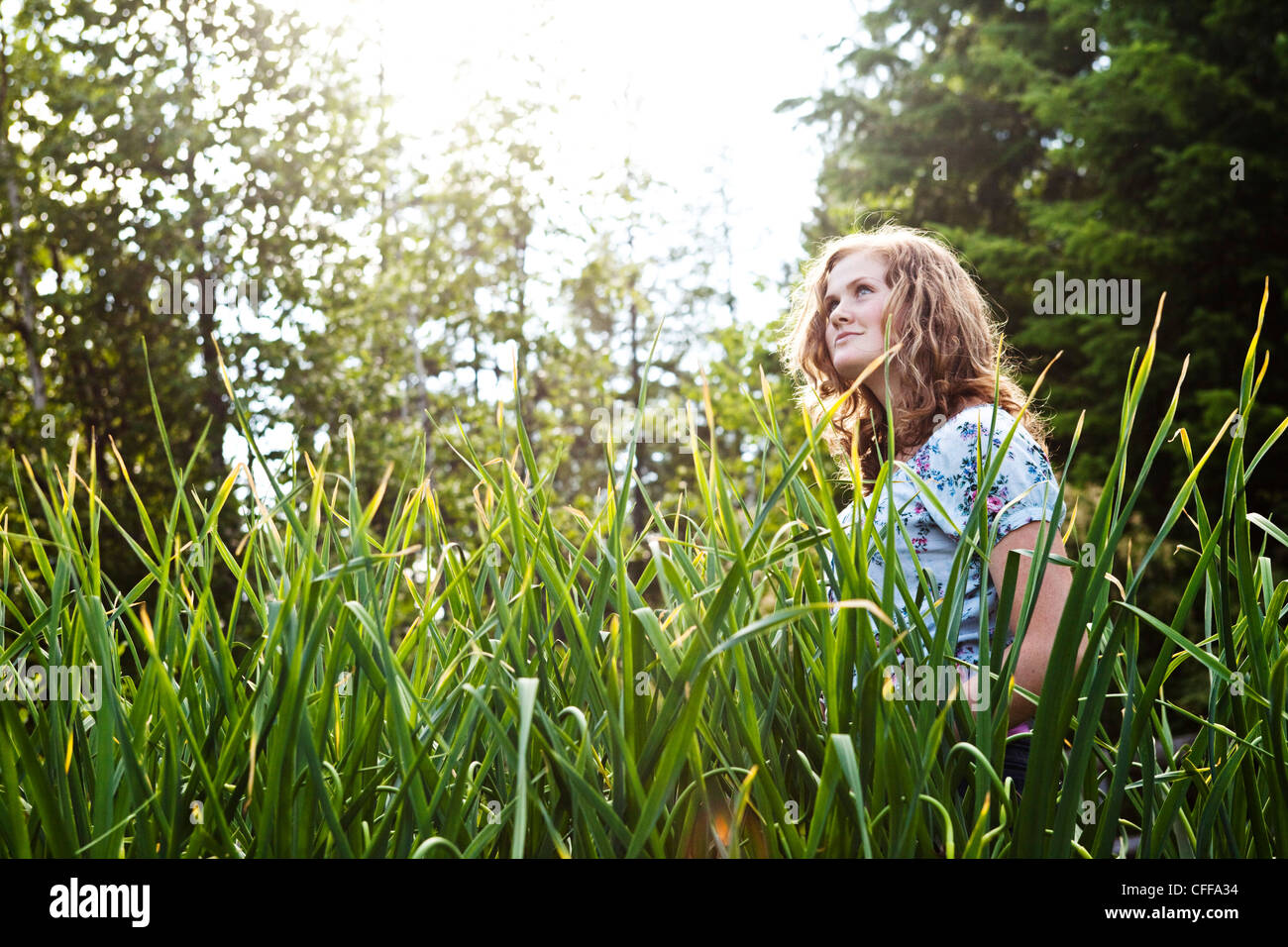 Une adolescente à la recherche dans la distance dans un jardin biologique dans l'Idaho. Banque D'Images