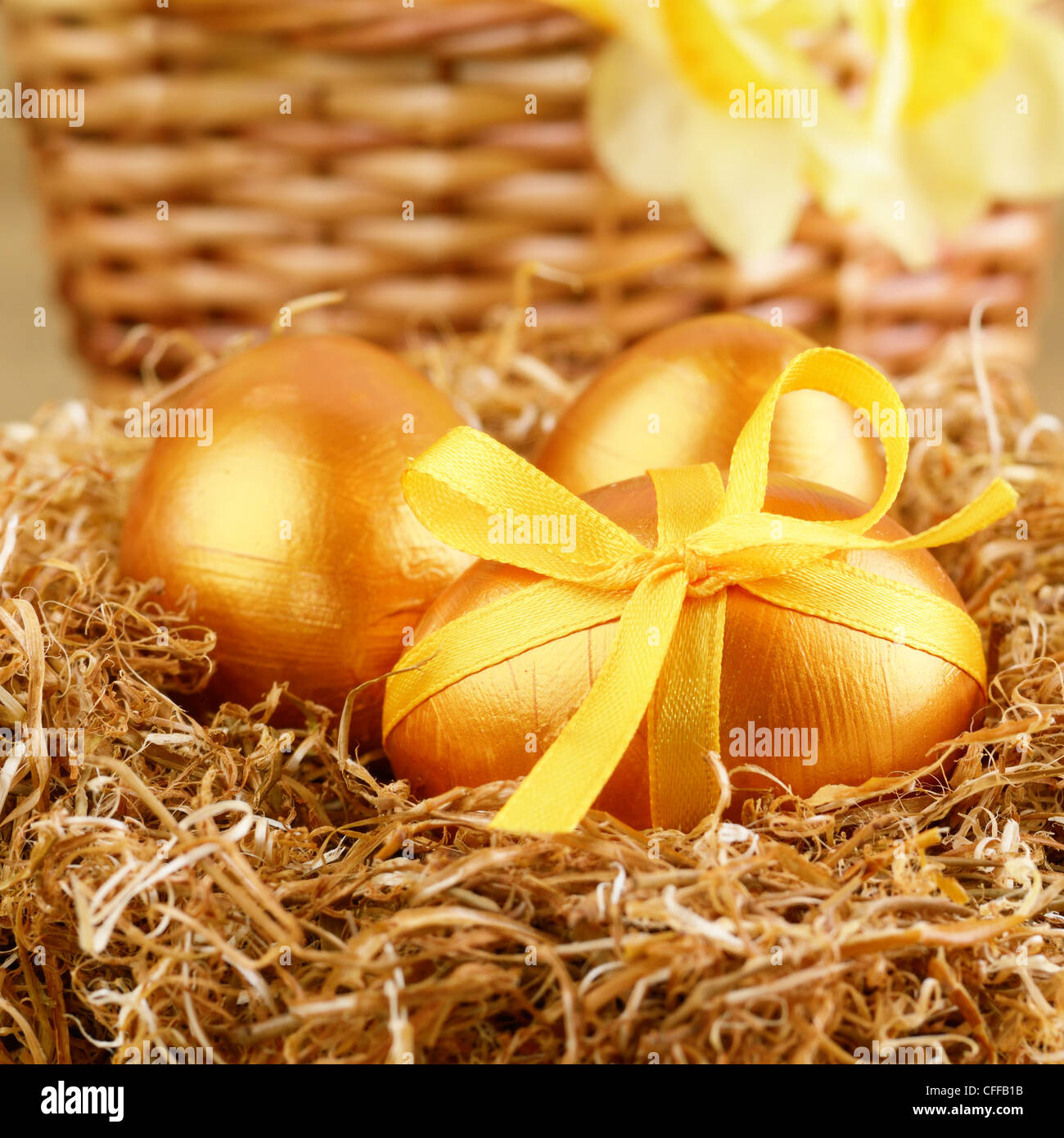 Les oeufs de pâques avec des arcs d'or dans le nid Banque D'Images
