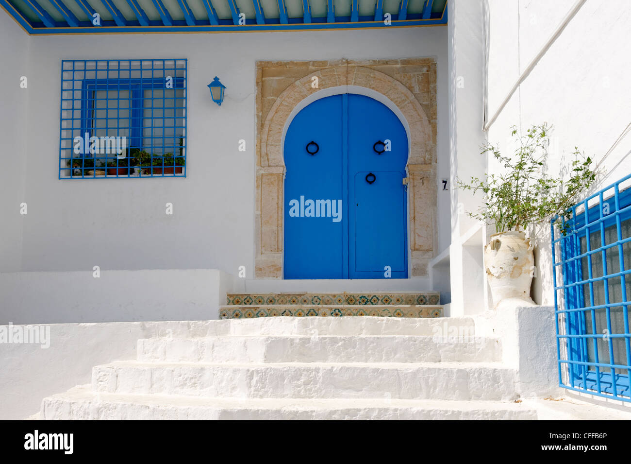 Sidi Bou Said. La Tunisie. Avis de marches menant jusqu'à une porte bleue avec ornementation dans la falaise Banque D'Images