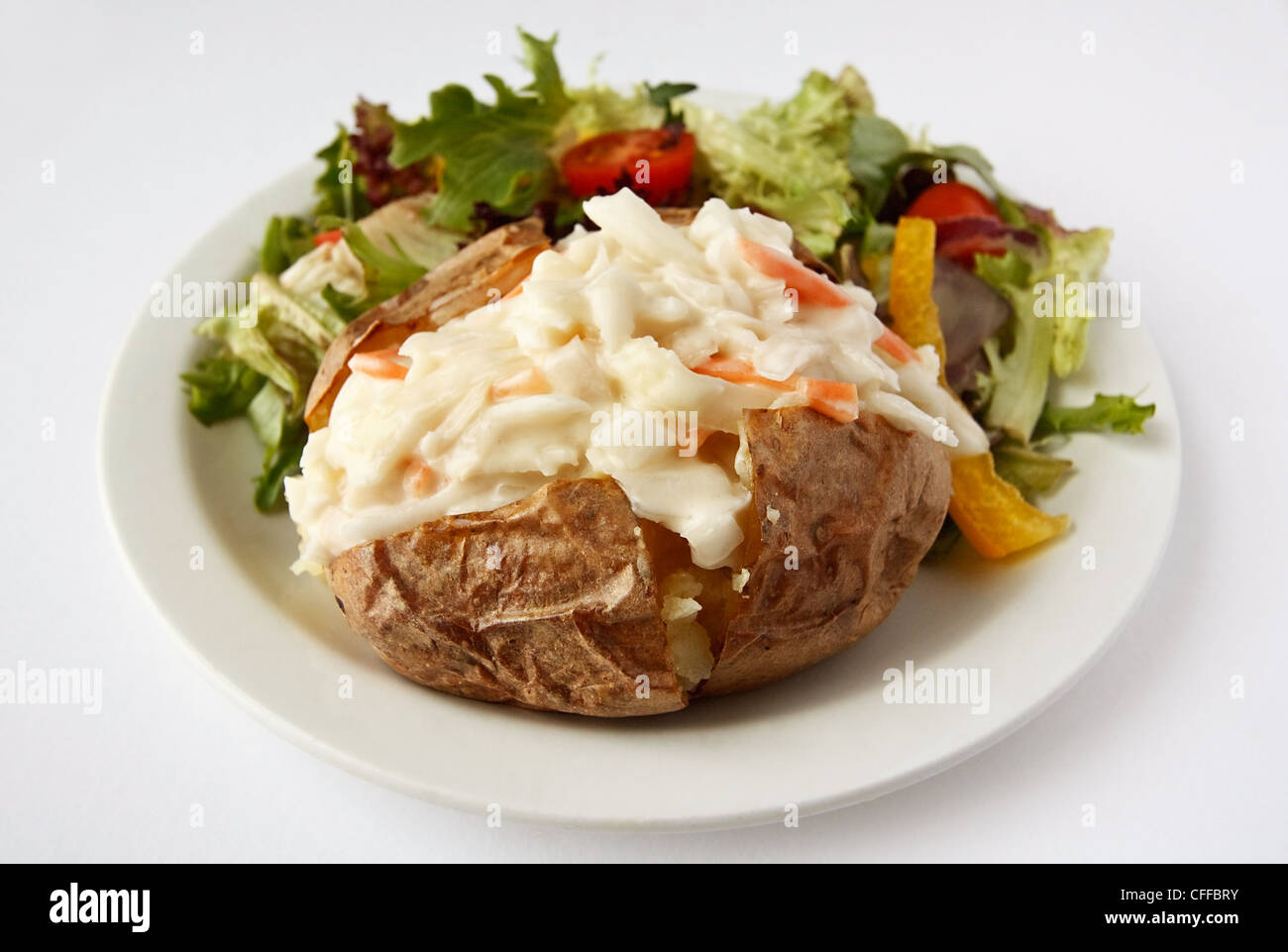 Une pomme de terre cuite au four avec remplissage de chou sur une assiette avec salade Banque D'Images
