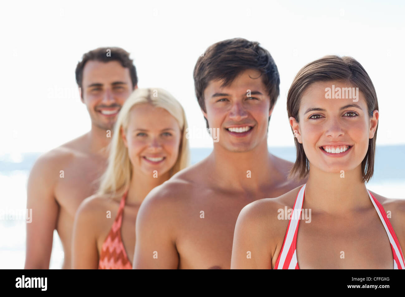 Woman smiling comme elle se tenir dans un seul fichier en face de ses trois amis Banque D'Images