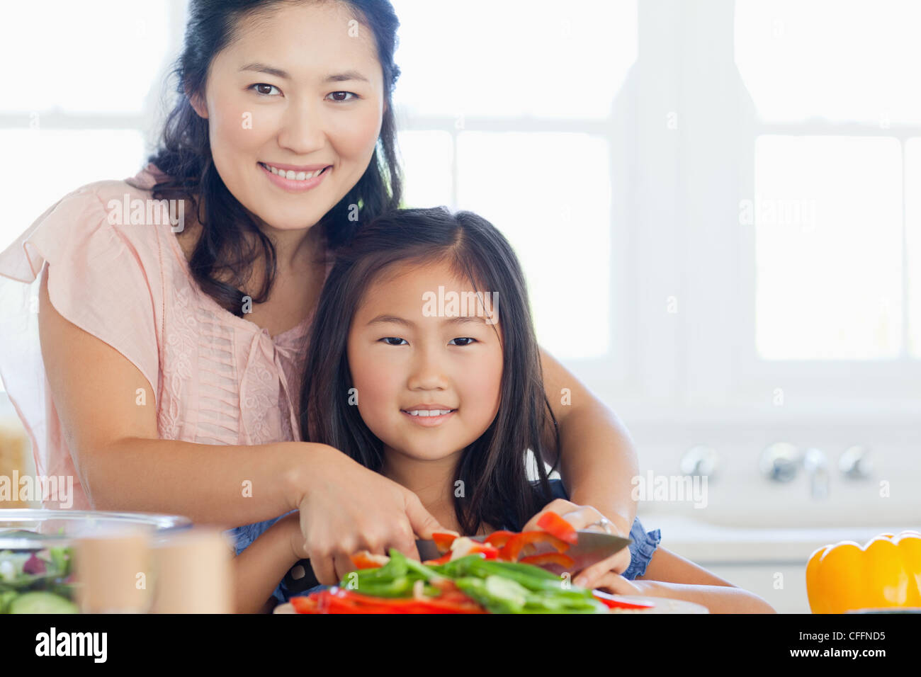 Une mère et sa fille hâte à préparer certains poivres Banque D'Images