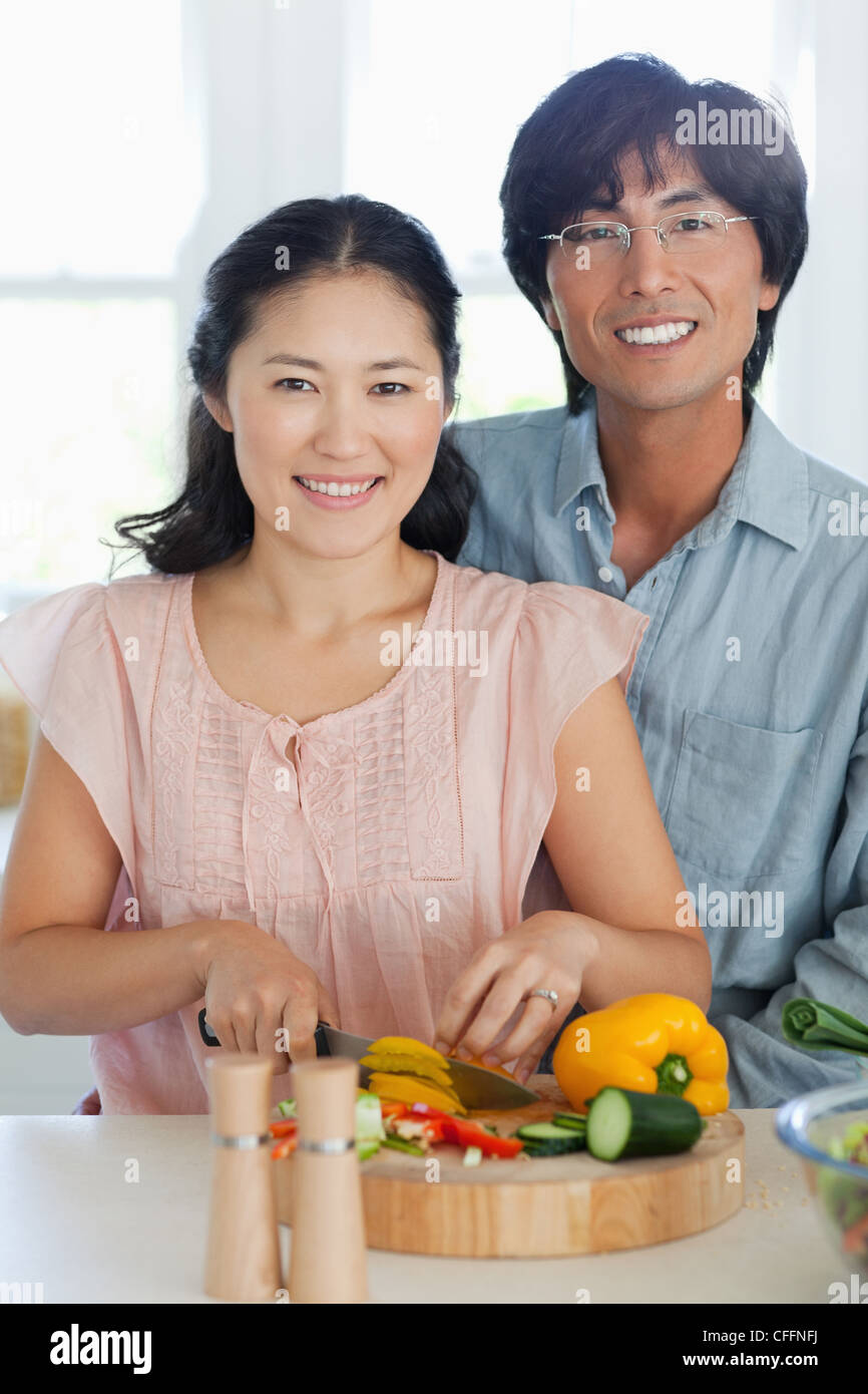Le mari et la femme hâte alors qu'ils préparent le dîner Banque D'Images
