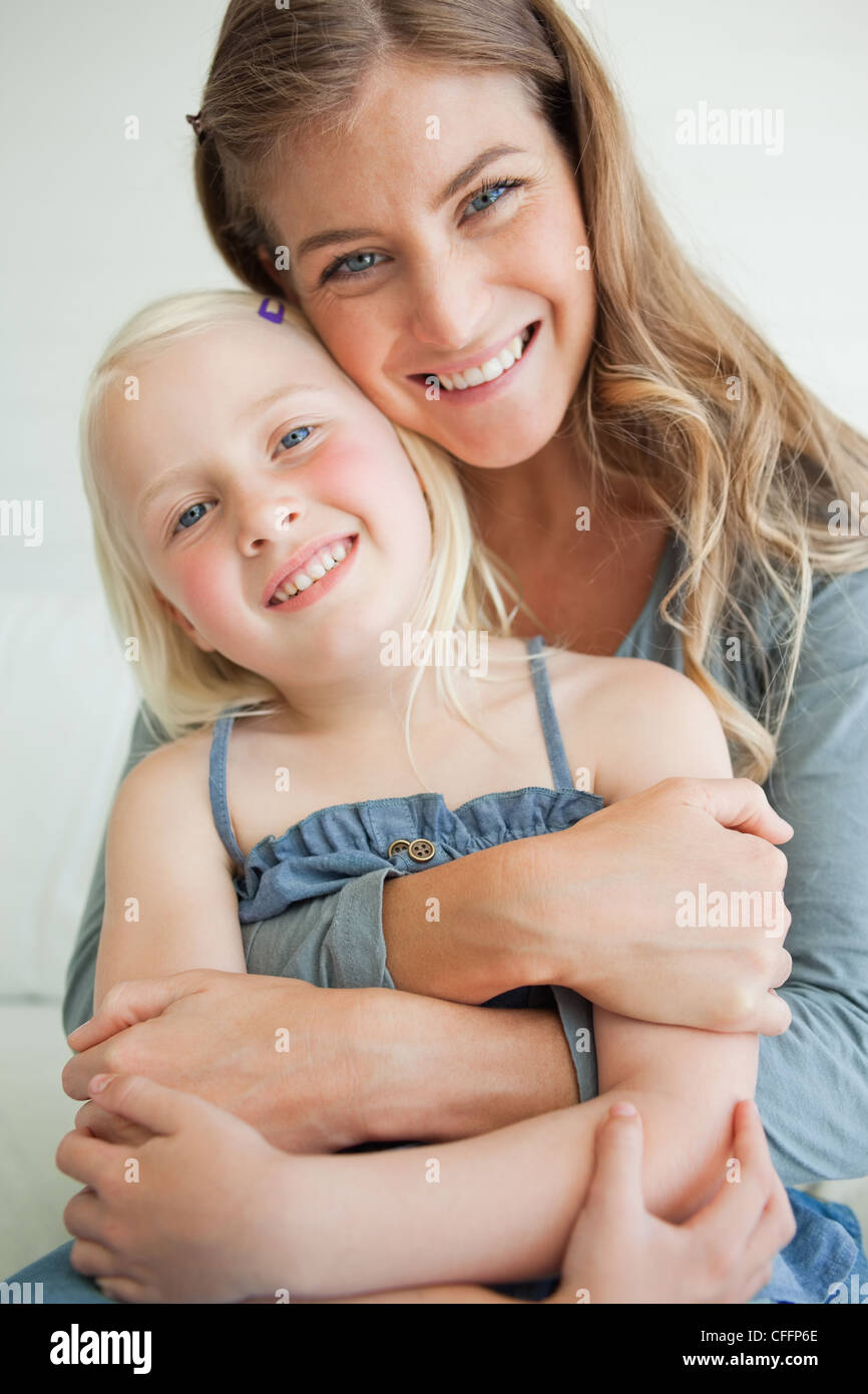 Close up of a smiling mother and daughter comme ils ont l'air de l'avant avec la tête inclinée Banque D'Images