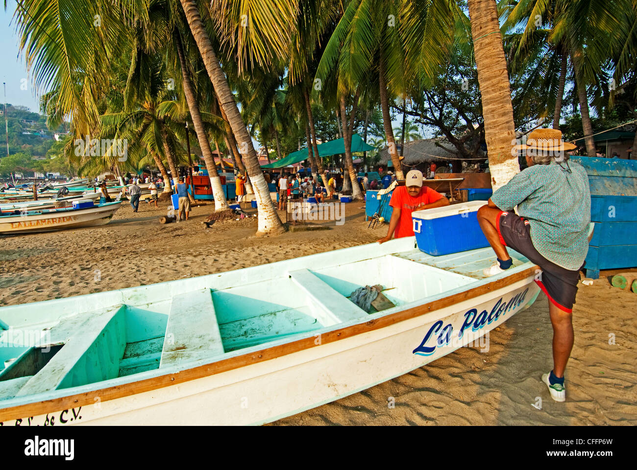 Un pêcheur son bateau de pêche sur la plage à Zihuatanejo, Mexique Banque D'Images