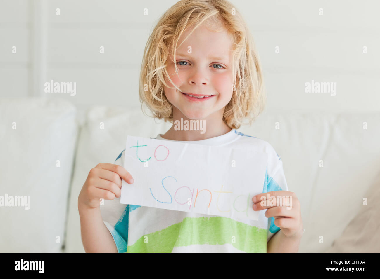 A smiling boy contient jusqu'sa lettre au père Noël Banque D'Images