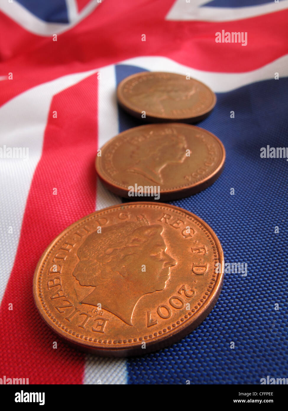 Trois pièces de cuivre sur un Union Jack flag , montrant le Queens Head dans sa jeunesse à l'heure actuelle. Banque D'Images