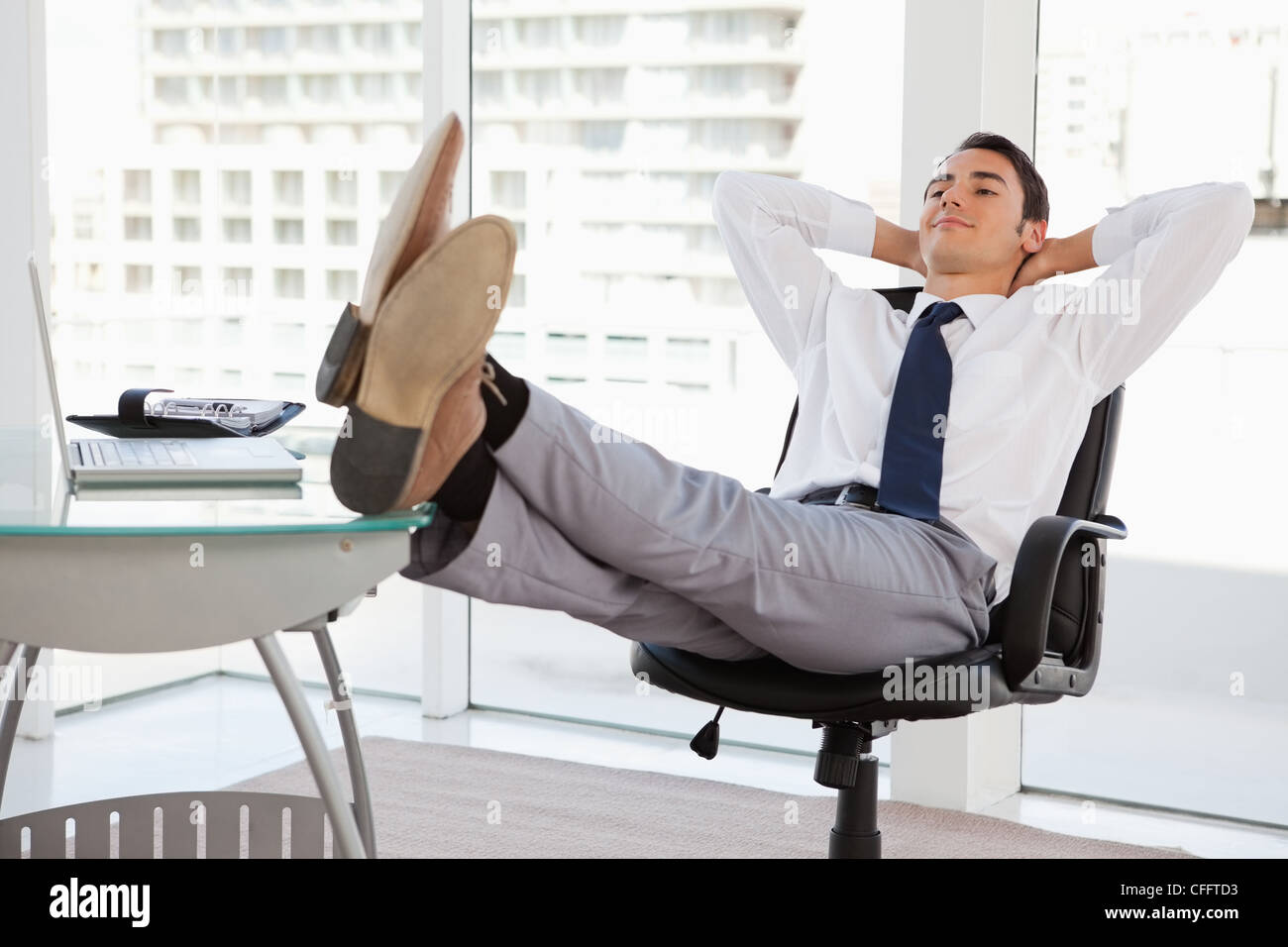 Happy businessman pieds sur son bureau Banque D'Images
