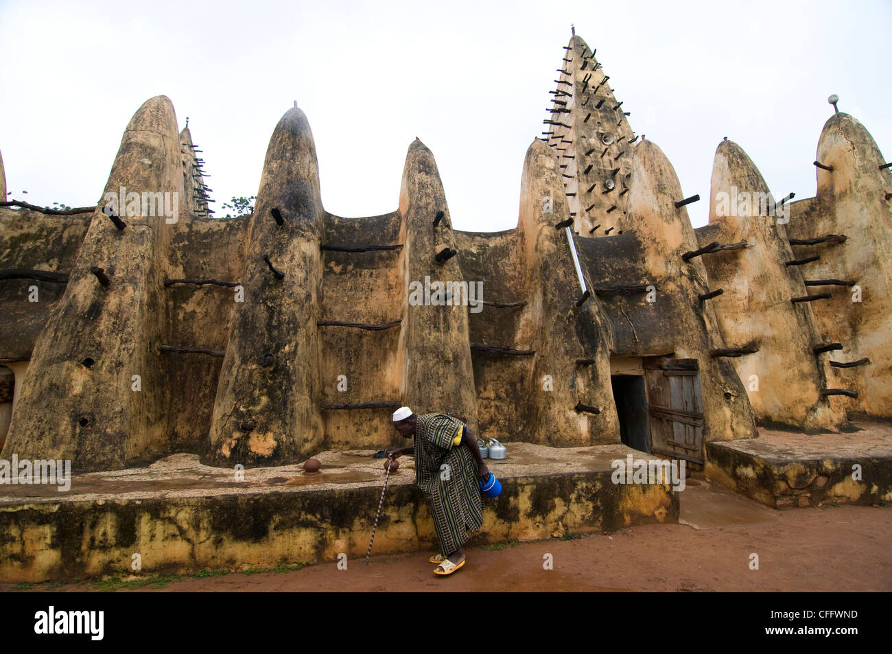 Un musulman marcher par la mosquée de style sahélien à Bobo Dioulasso, Burkina Faso. Banque D'Images