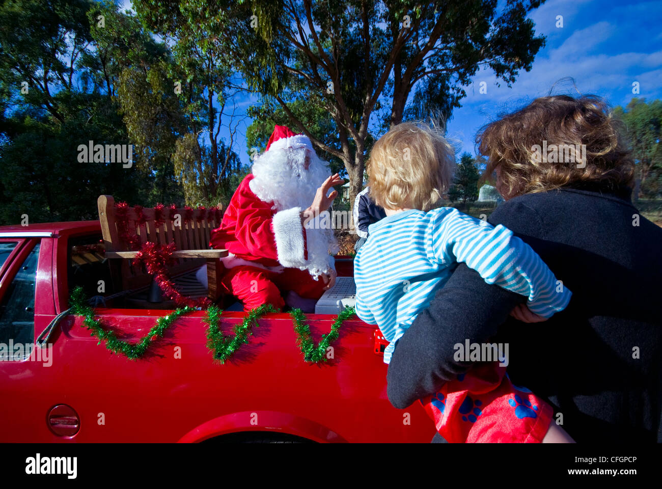 Père Noël dans une ville à la campagne répond à un petit garçon le jour de Noël. Banque D'Images