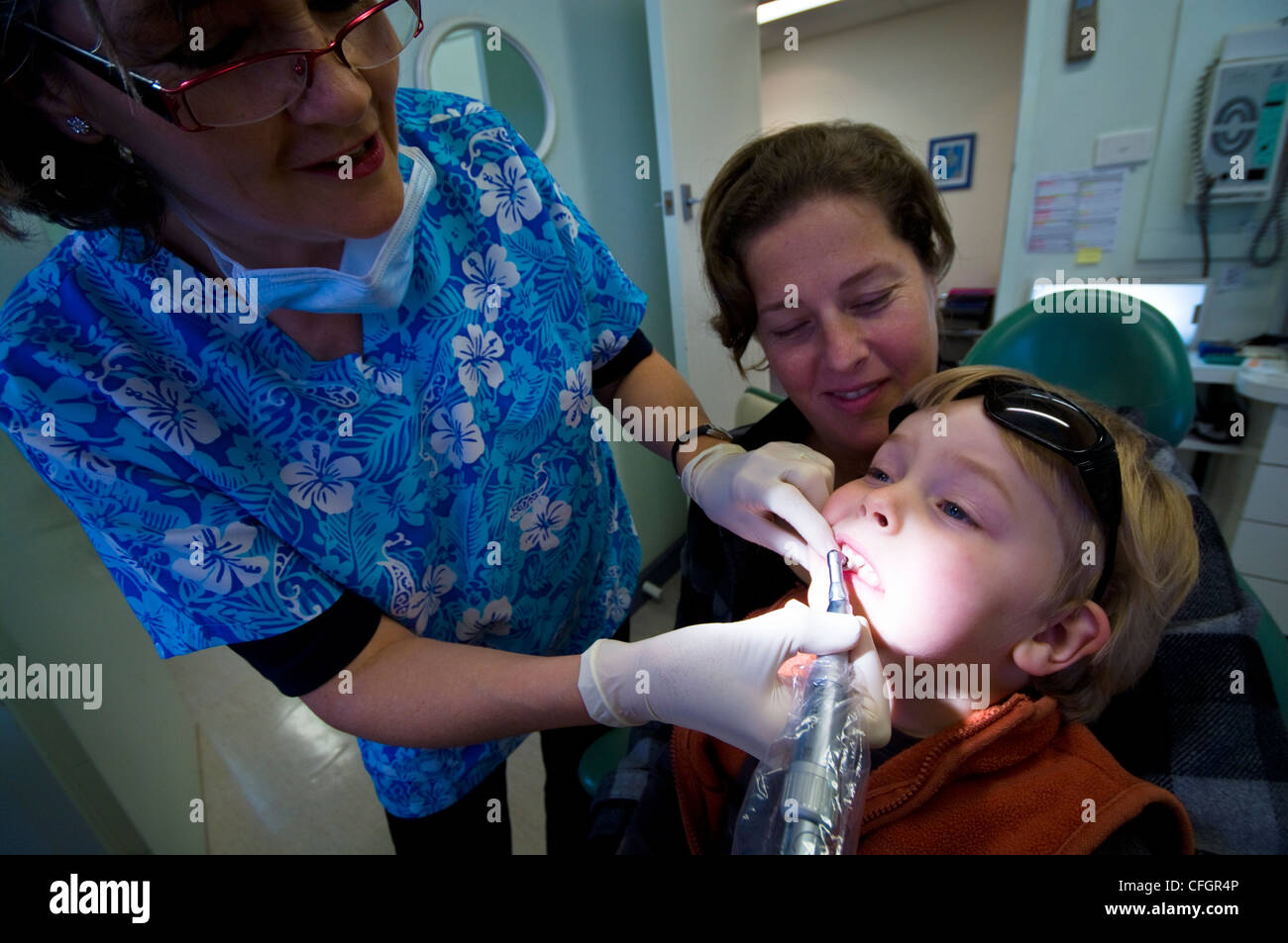 Un dentiste polit les dents d'un garçon à son premier examen dentaire. Banque D'Images