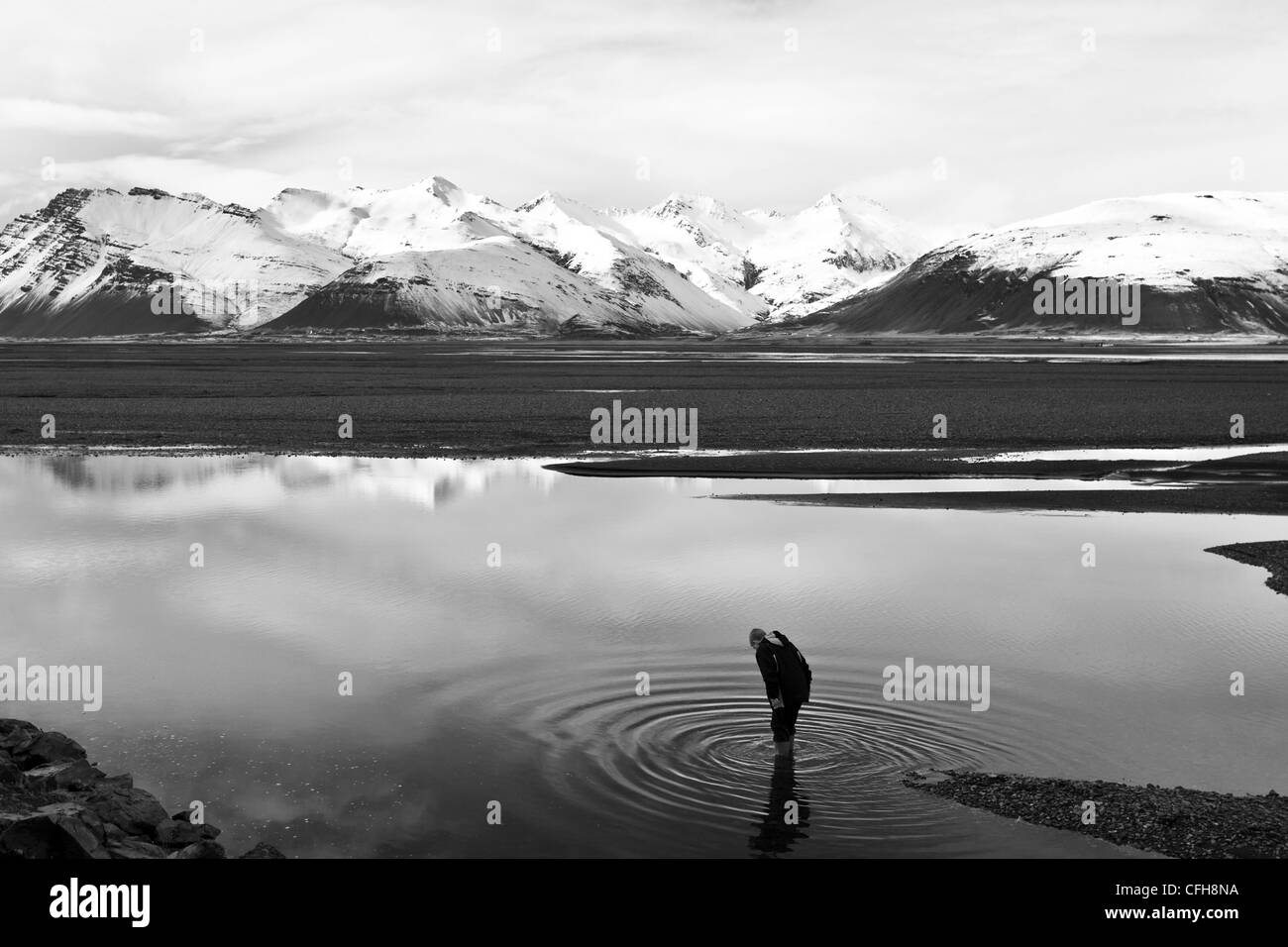 Garçon debout dans un lac, près de Hofn, Islande Banque D'Images