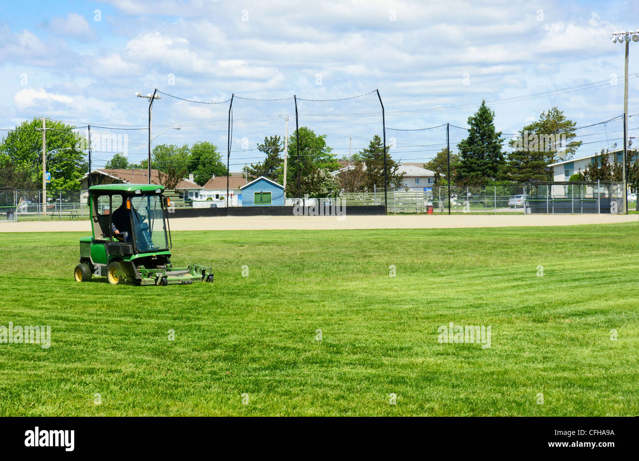 Petit tracteur de couper le gazon du terrain de baseball avant le jeu. Banque D'Images