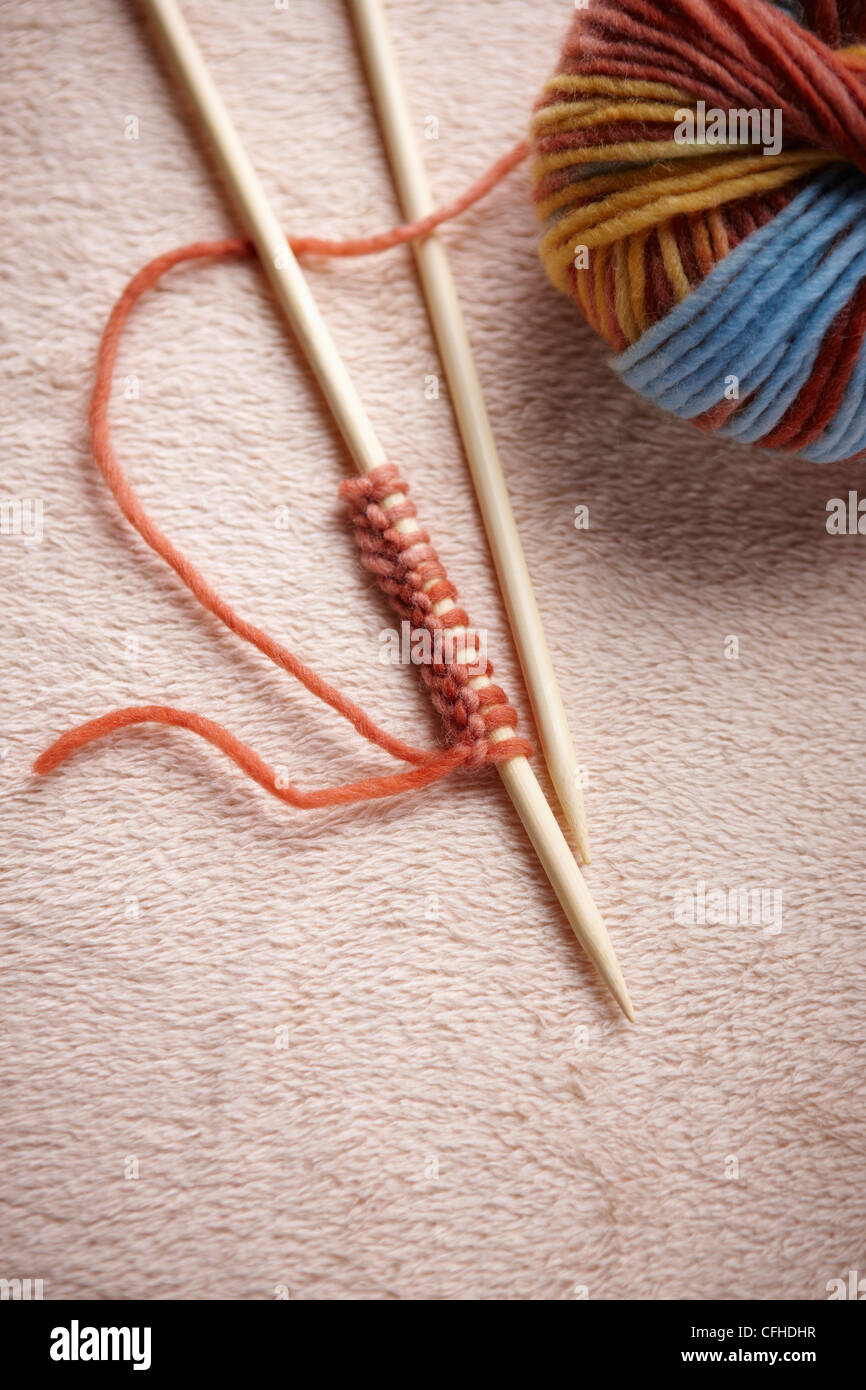 Une balle de laine colorés avec une paire d'aiguille à tricoter Banque D'Images