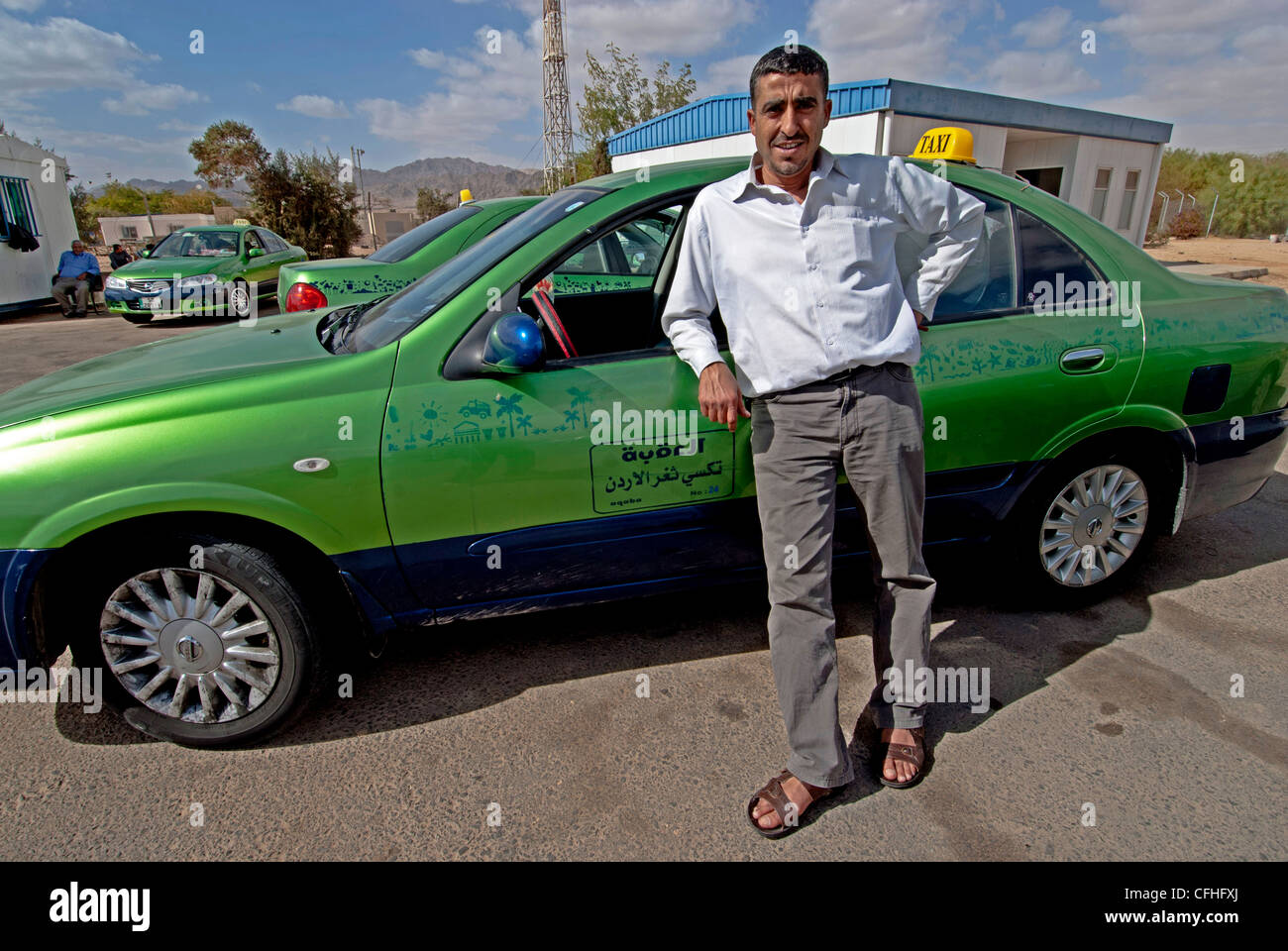 Un chauffeur de taxi et sa cabine à la Jordanie Wadi Araba Crossing/sud reliant la frontière Eilat et Aqaba. Banque D'Images