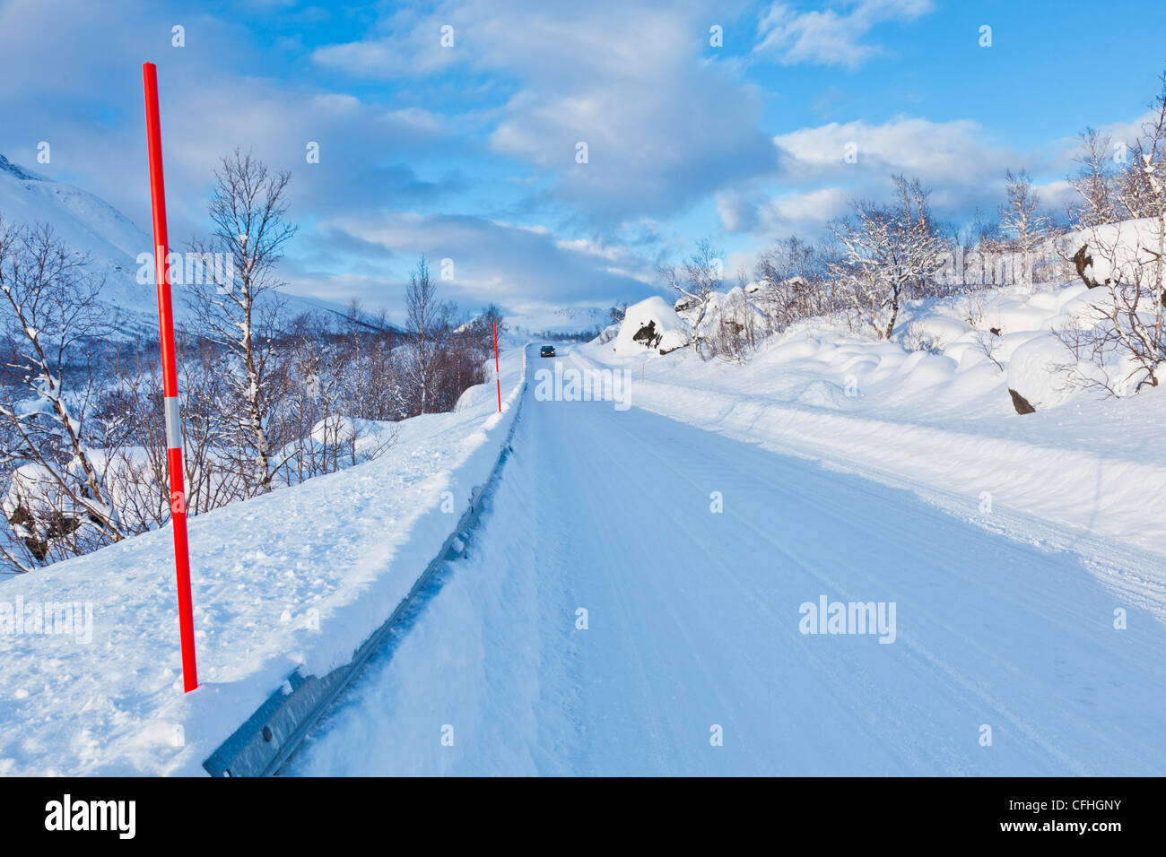 Voiture à distance sur la route couverte de neige près de Sjursnes Troms Norvège du Nord Scandinavie Europe Banque D'Images