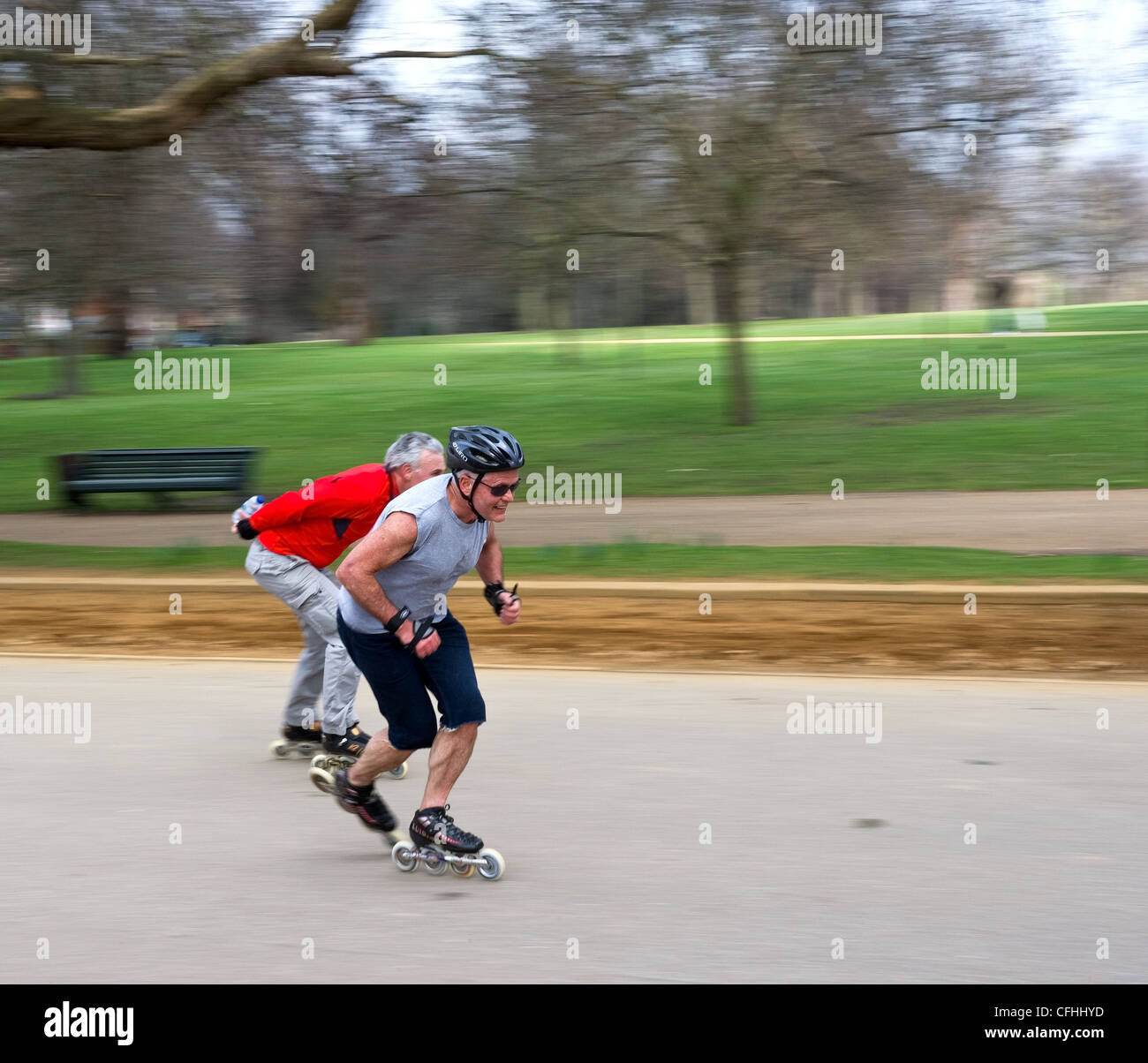 Deux hommes en patinage de vitesse à travers Hyde Park à Londres Banque D'Images