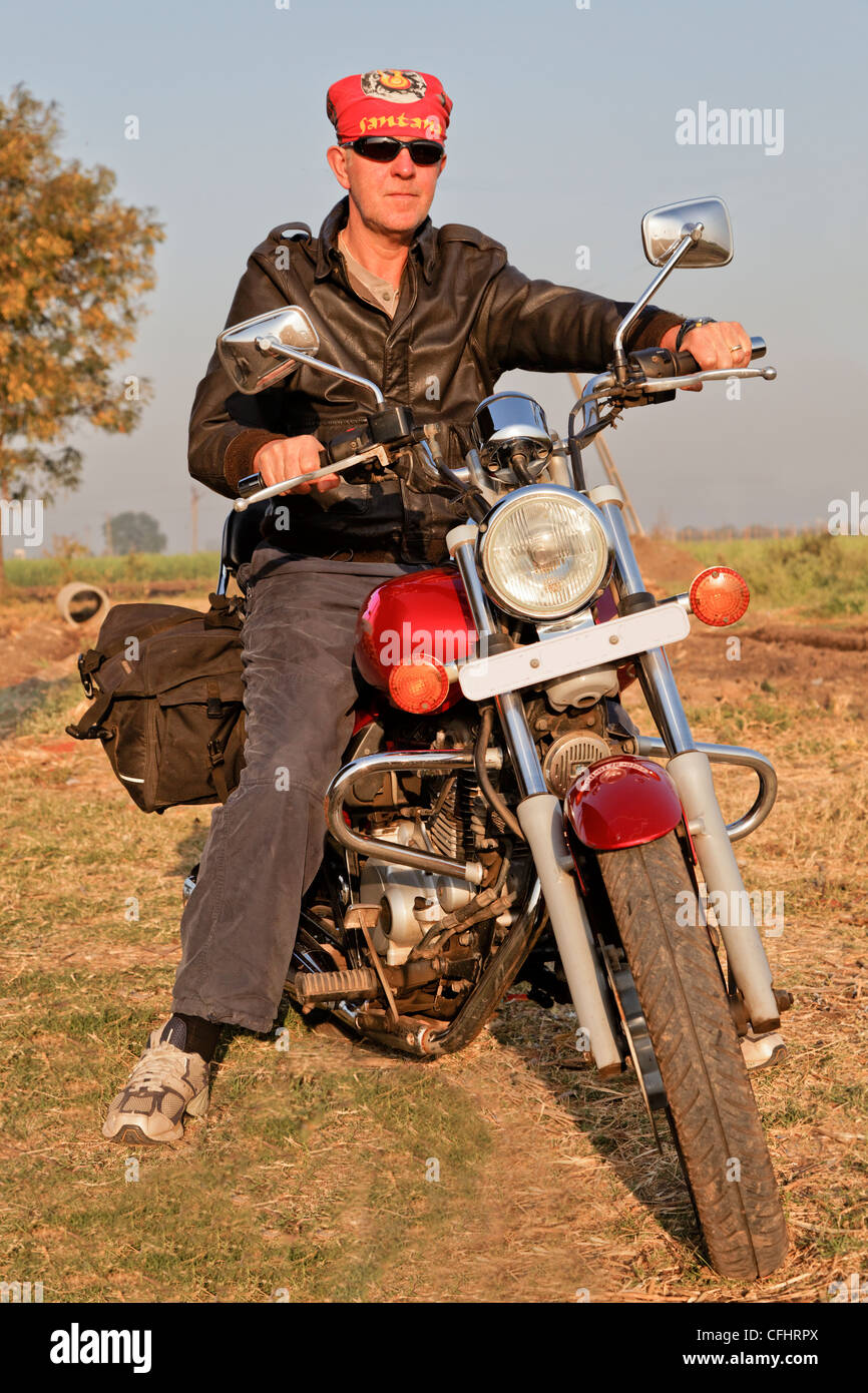 Portrait d'angle bike rider en tournée en Inde int il arrière-pays et des terres agricoles de Gujarat Banque D'Images