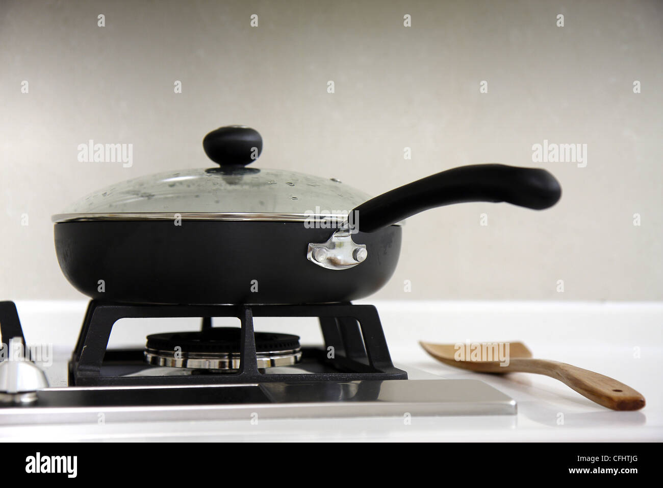 Une cuisine équipée d''une plaque de cuisson avec une casserole et une louche en bois. Banque D'Images