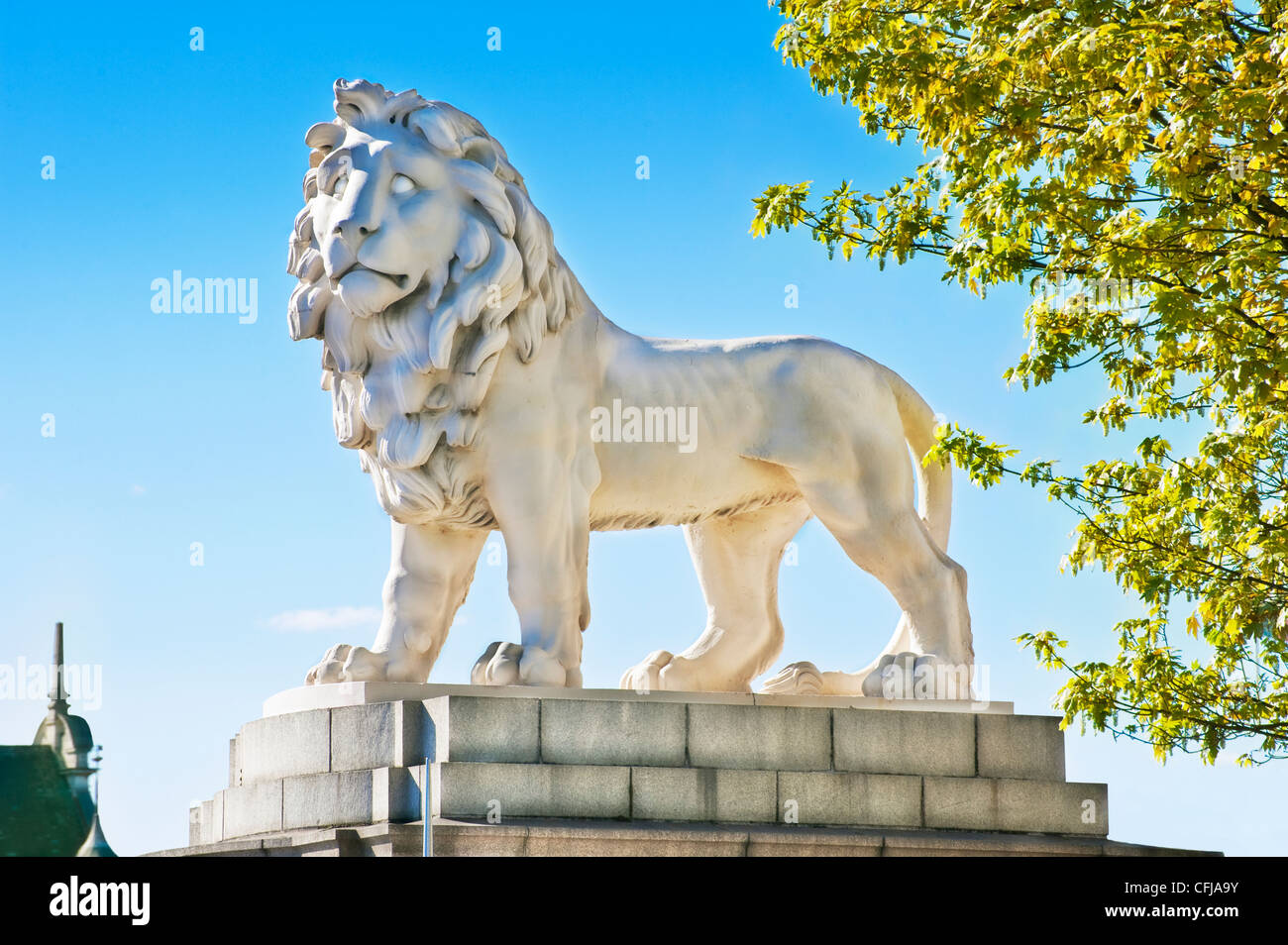 Majestueux massif 13 tonne white lion sculpture se dresse fièrement sur un socle élevé en plein soleil sur le pont de Westminster, Londres Banque D'Images