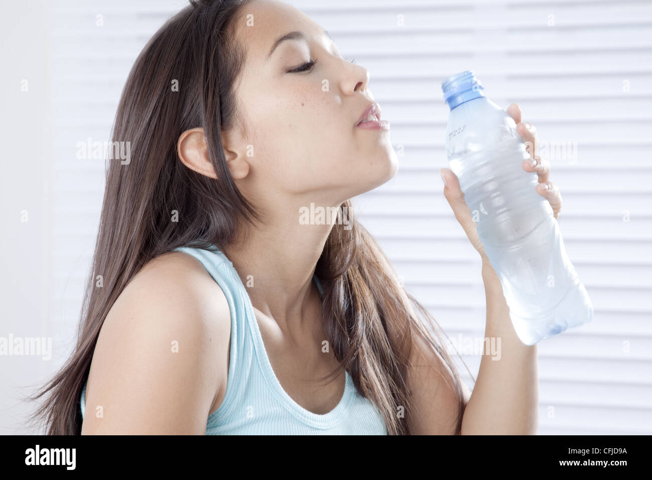 Jeune femme à boire de l'eau en bouteille Banque D'Images