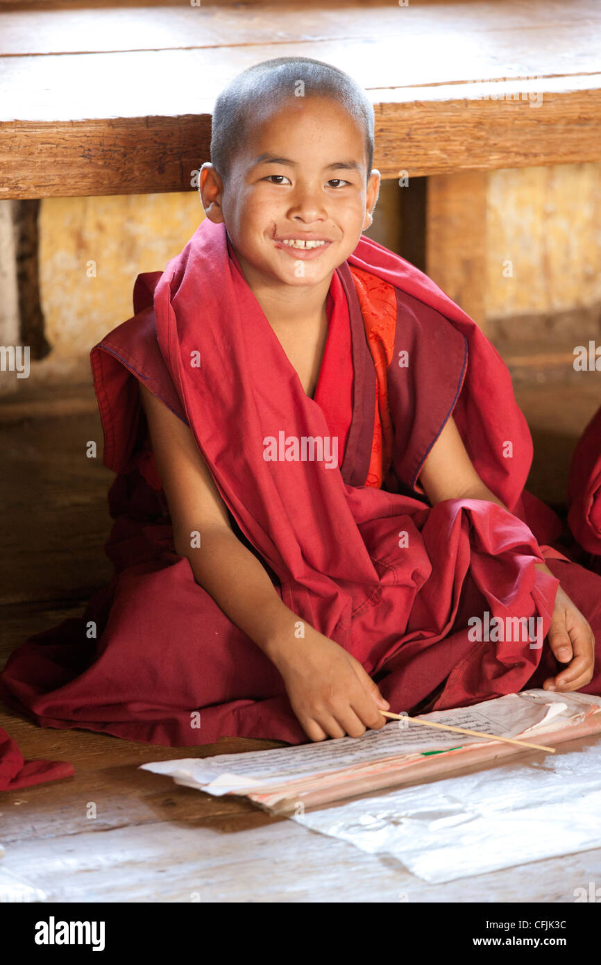 L'étude de jeune moine bouddhiste de scripts en classe à Chimi Lhakhang temple, la vallée de Punakha, Bhoutan, Asie Banque D'Images